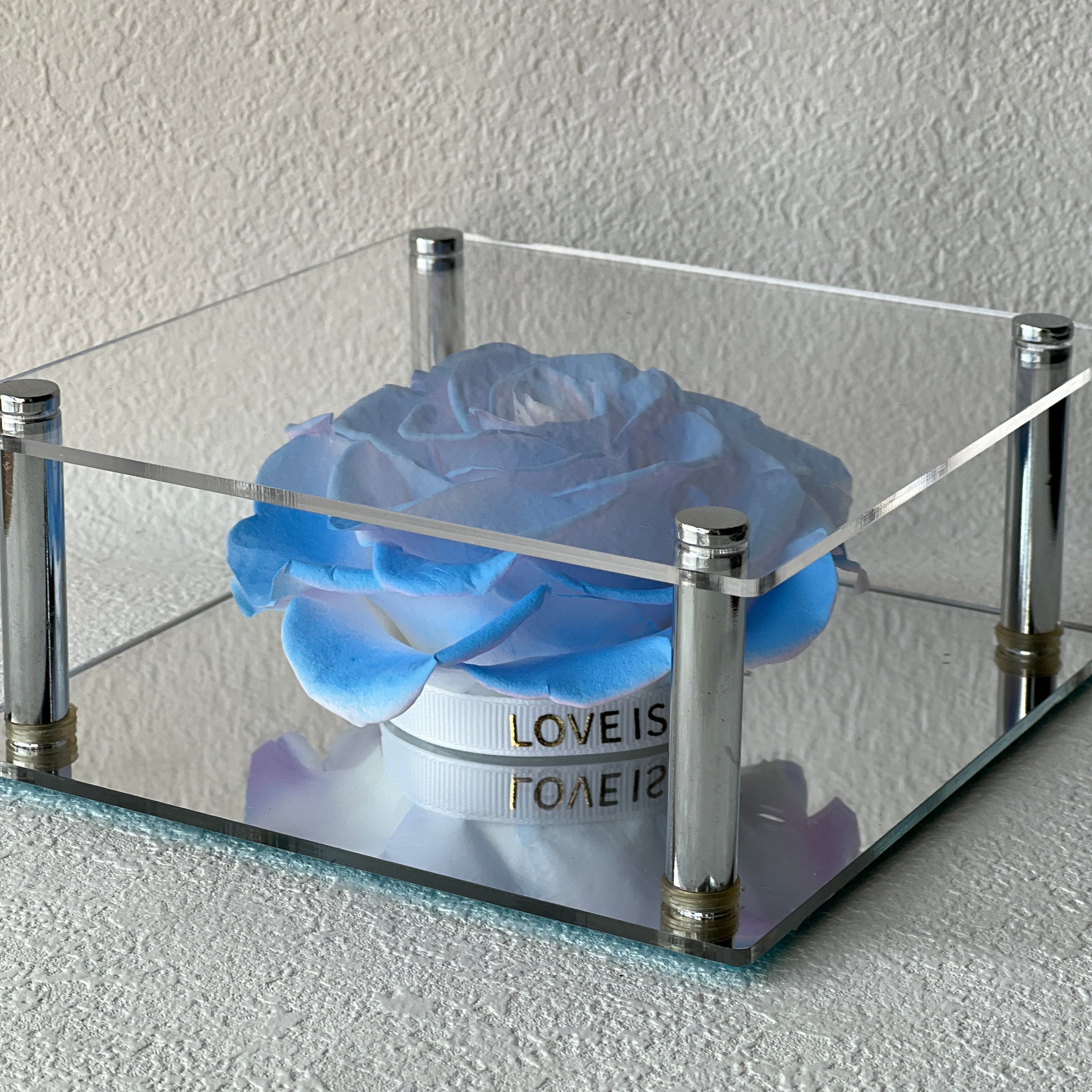 Solitary Splendor featuring a single stunning preserved blue peony in an acrylic box with a glass mirror bottom. A graceful eternity flower gift perfect for expressing admiration, love, or gratitude.