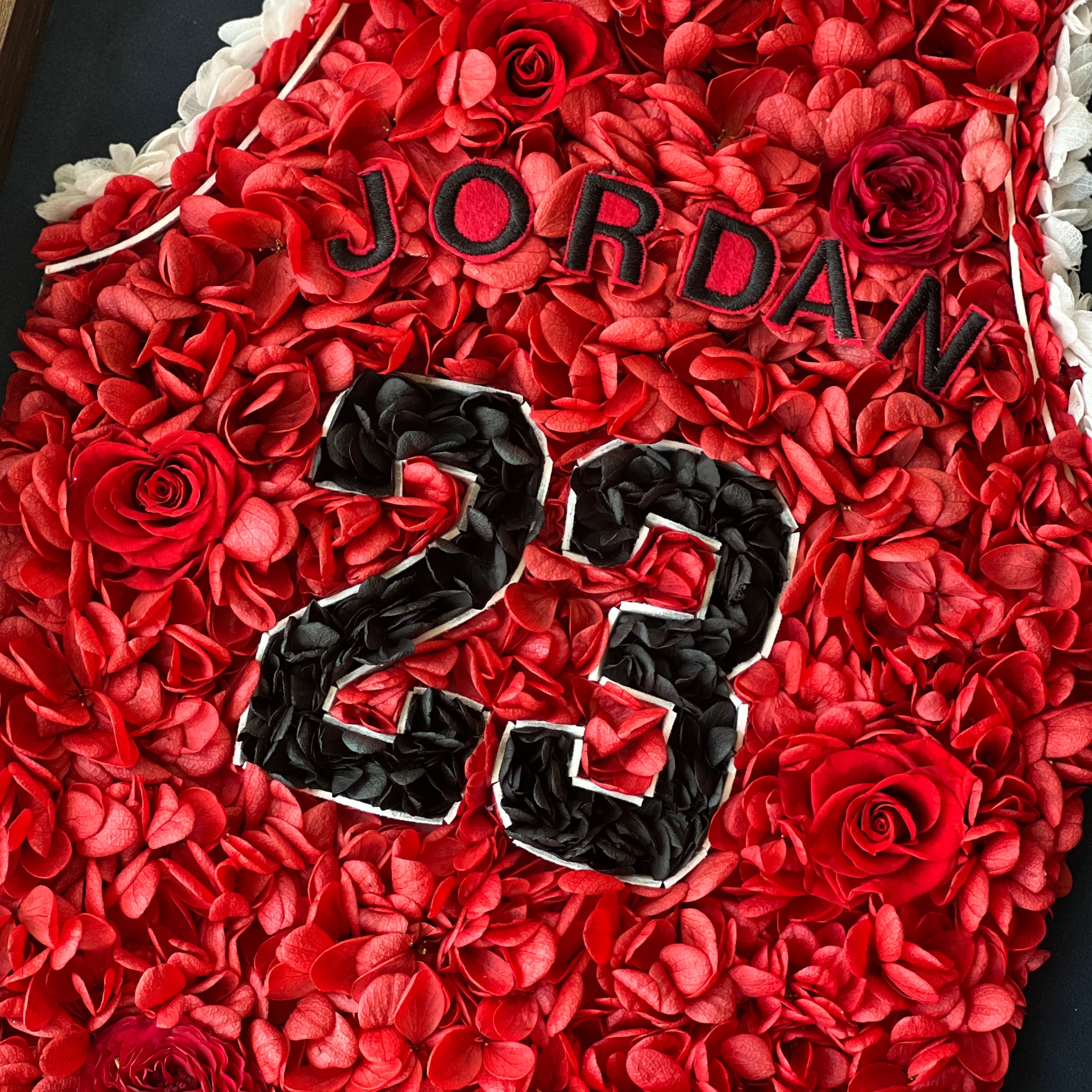 Preserved floral artwork inspired by Michael Jordan's iconic red jersey, featuring roses and hydrangeas. Perfect for sports fans and collectors, adding a bold, botanical touch.