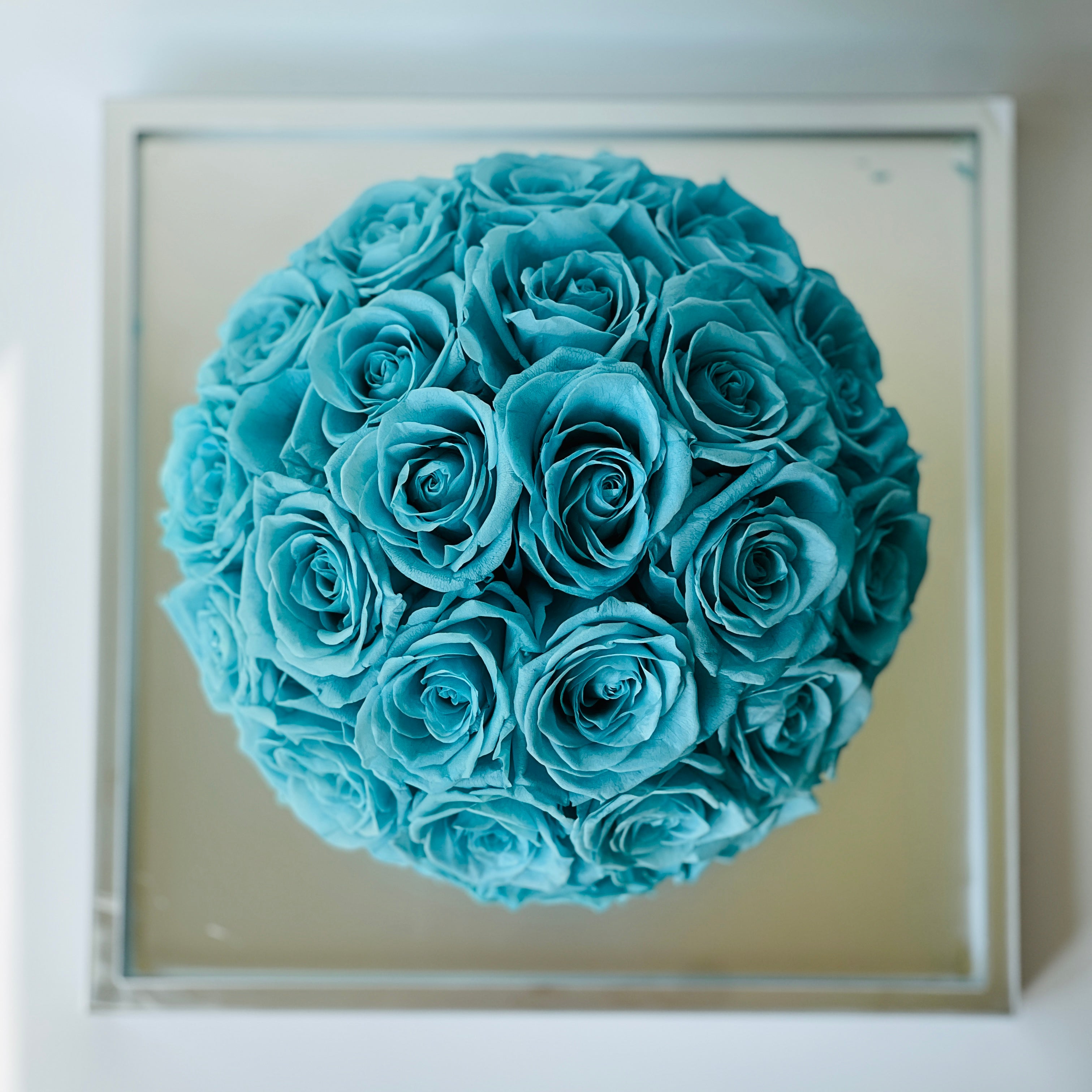 The Tiffany Blue Rose Hatbox features preserved roses on a sleek grey base inscribed with "love is eternal." This serene eternity rose arrangement offers a modern statement of enduring affection, perfect for adding tranquility to any space or as a heartfelt gift.