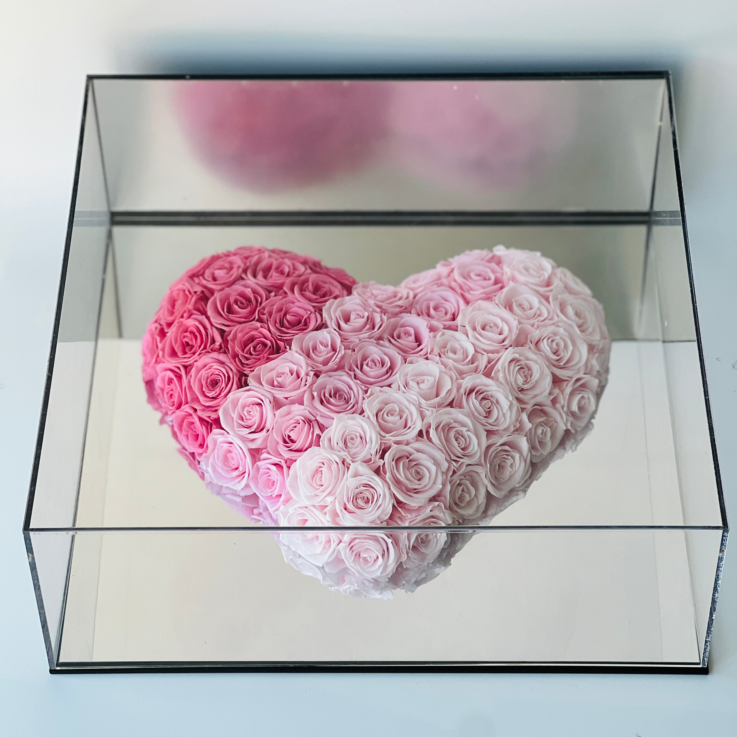 Captivating heart-shaped preserved roses in an ombré design, transitioning from deep pink to blush. This eternity rose arrangement is a timeless symbol of love.