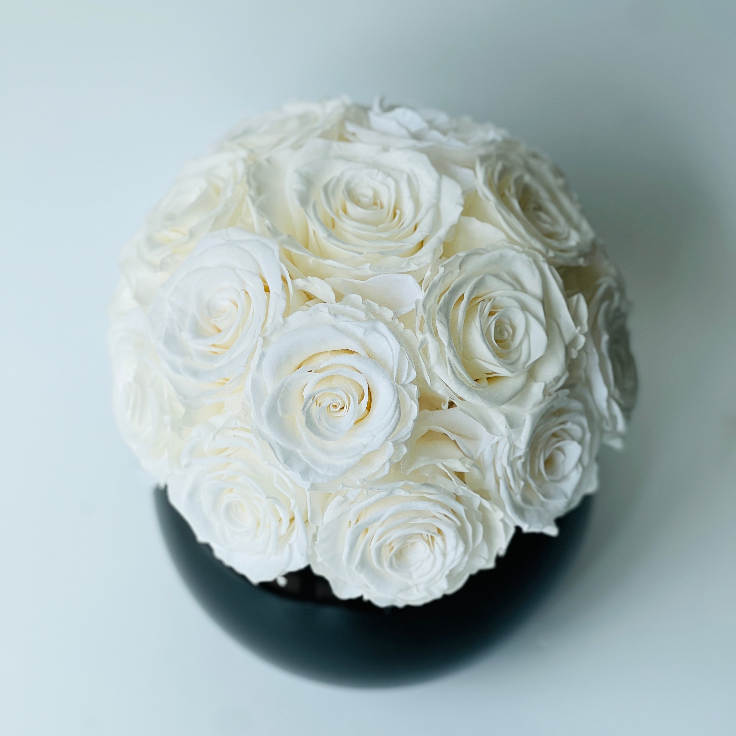 Ecuadorian White Roses in Black Vase: A striking sphere of preserved roses in a glossy vase, perfect for adding a touch of elegance to any space—no maintenance required.