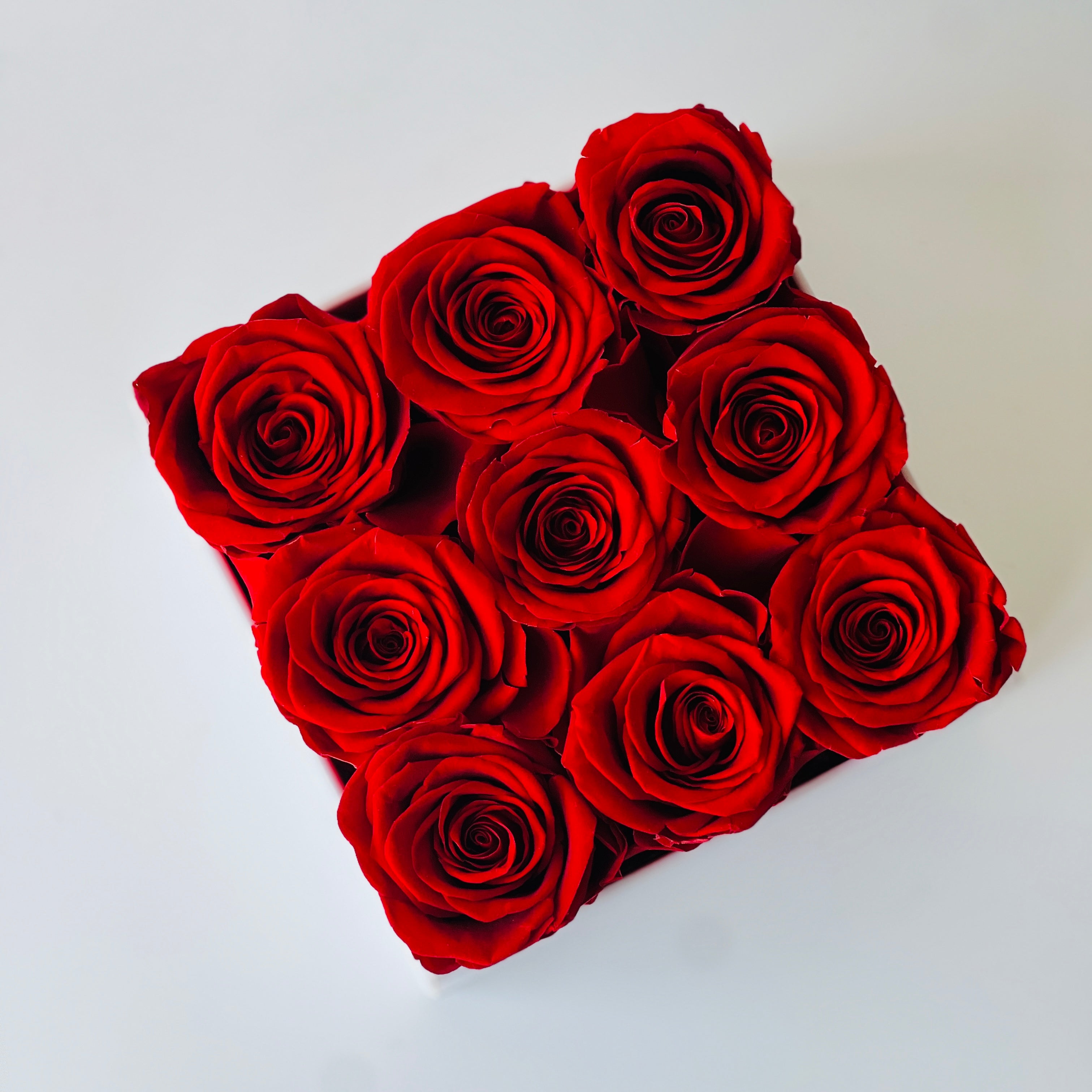 Signature Rose Floral Box featuring 11 preserved red roses arranged in a classic white hatbox. This luxurious eternity rose gift is perfect for adding elegance to any space or gifting on special occasions like Valentine's Day or anniversaries.