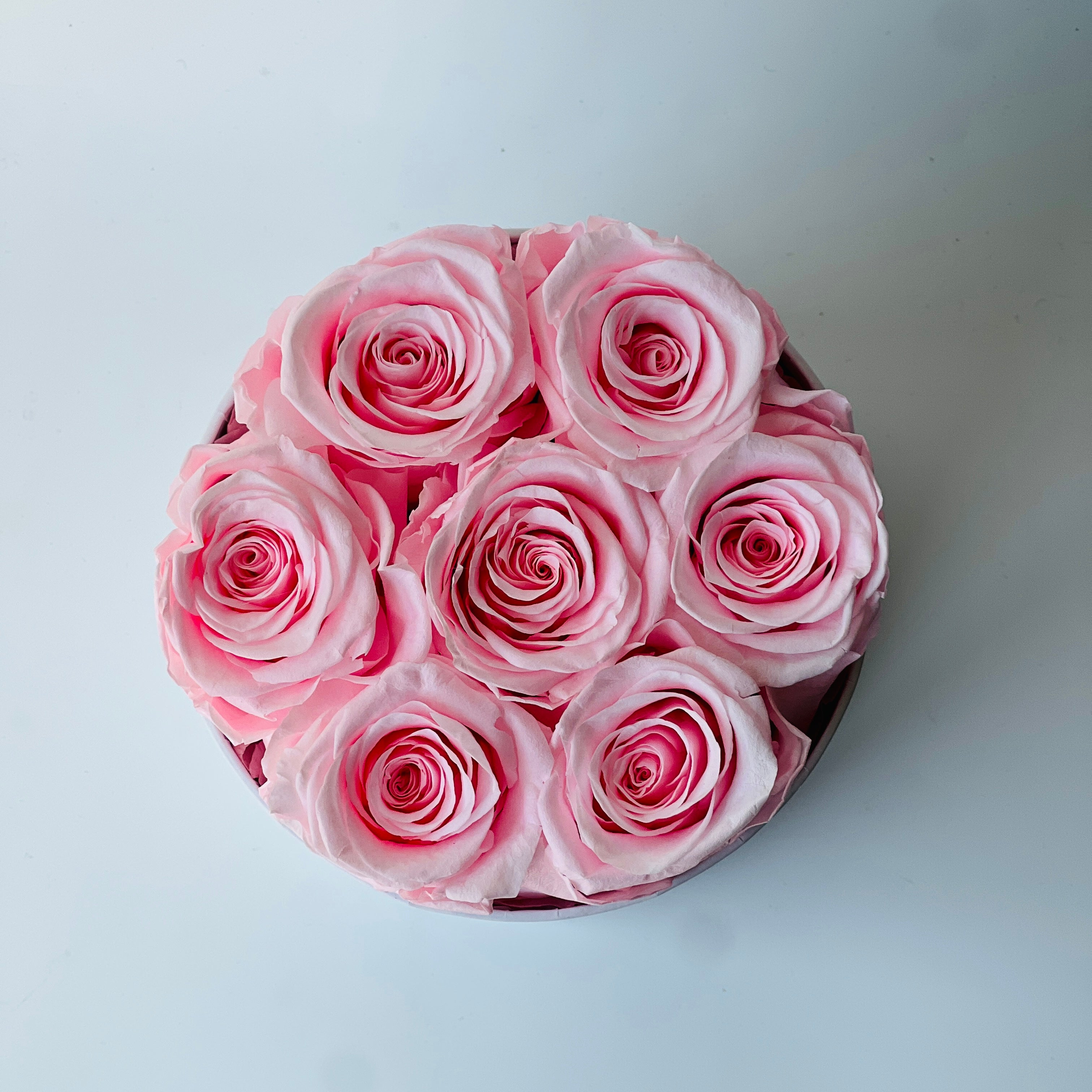 The Preserved Red Roses Hat Box is filled with vibrant red roses, elegantly arranged in a luxurious gold and black container. This timeless eternity rose gift adds a touch of elegance to any space, perfect for special occasions like Valentine's Day or anniversaries.