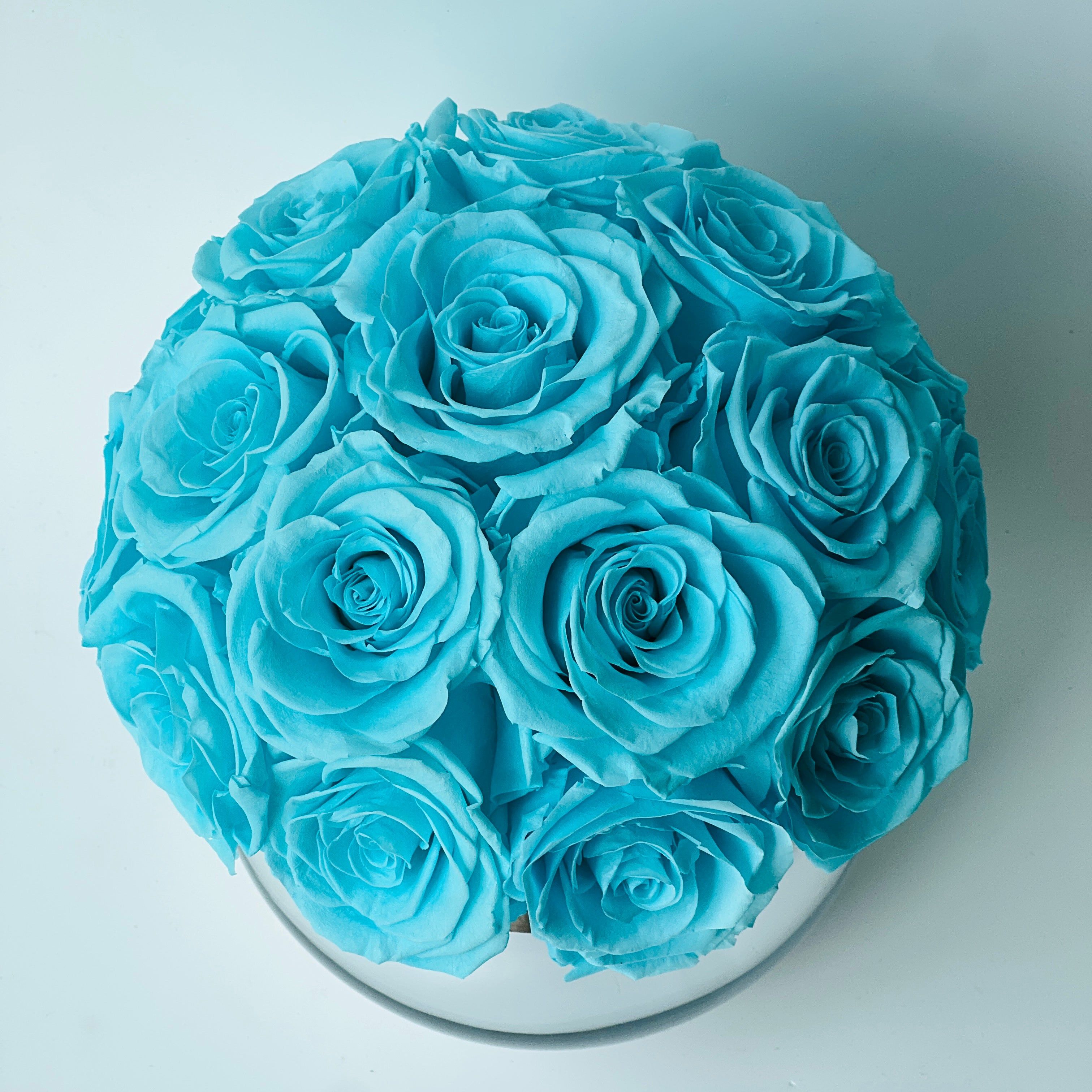 Tiffany Blue Rose Hatbox: Preserved blue roses on a sleek grey base inscribed with love is eternal. Elegant, tranquil, and perfect for any special occasion.