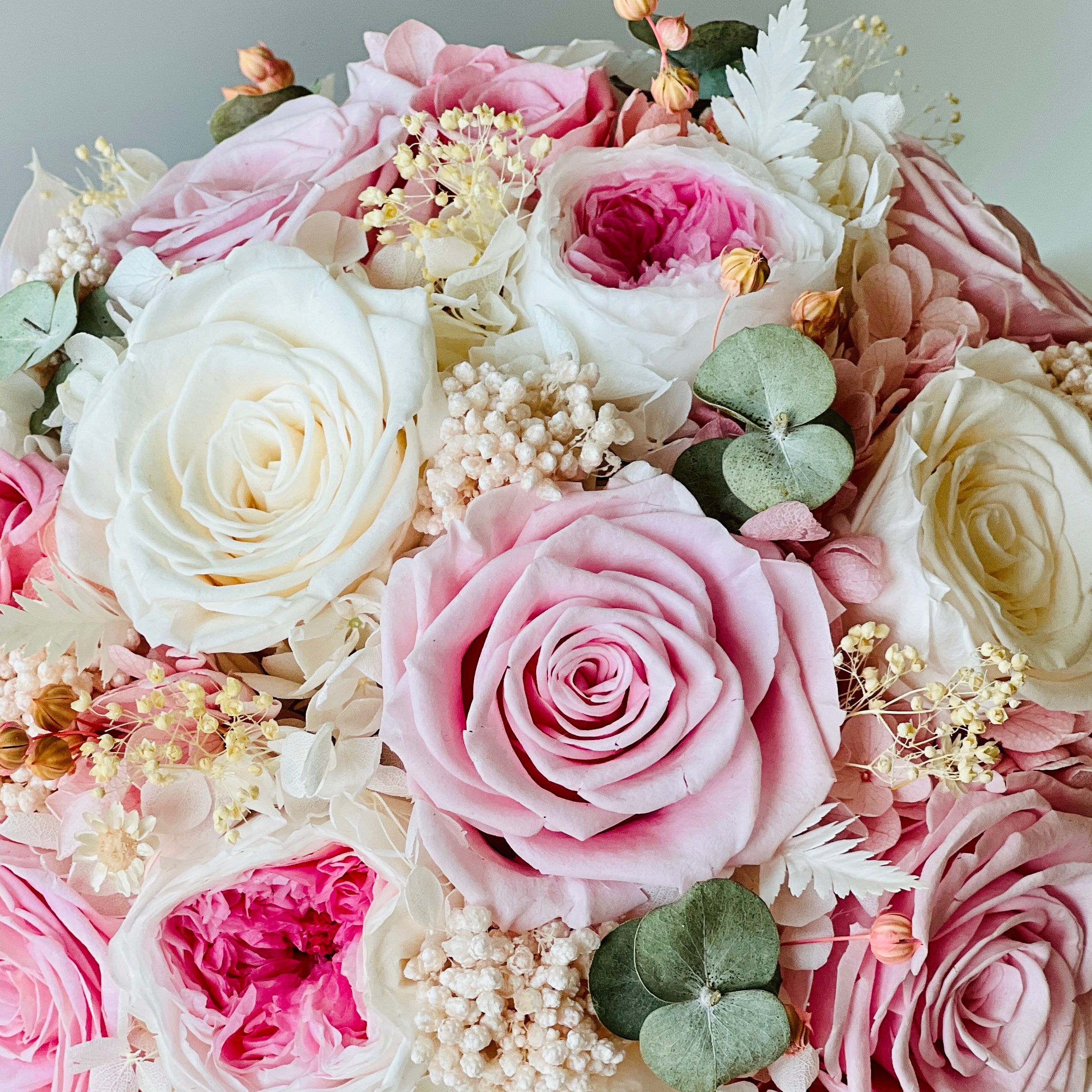 Blushing Beauty Bouquet: Preserved pink and white roses with hydrangeas and baby's breath, accented by soft greenery in an elegant vase. Ideal for gifting.