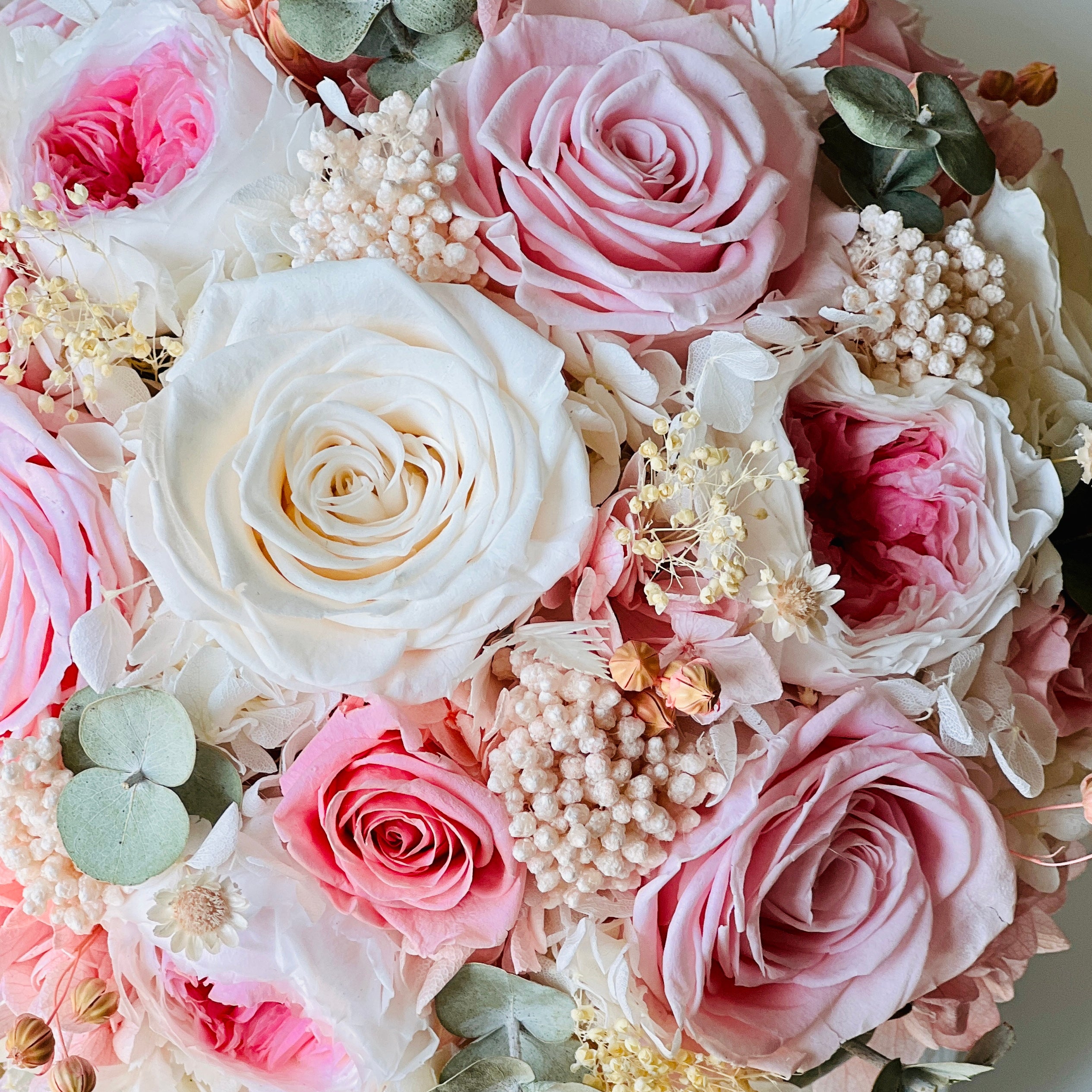 Blushing Beauty Bouquet: Preserved pink and white roses with hydrangeas and baby's breath, accented by soft greenery in an elegant vase. Ideal for gifting.