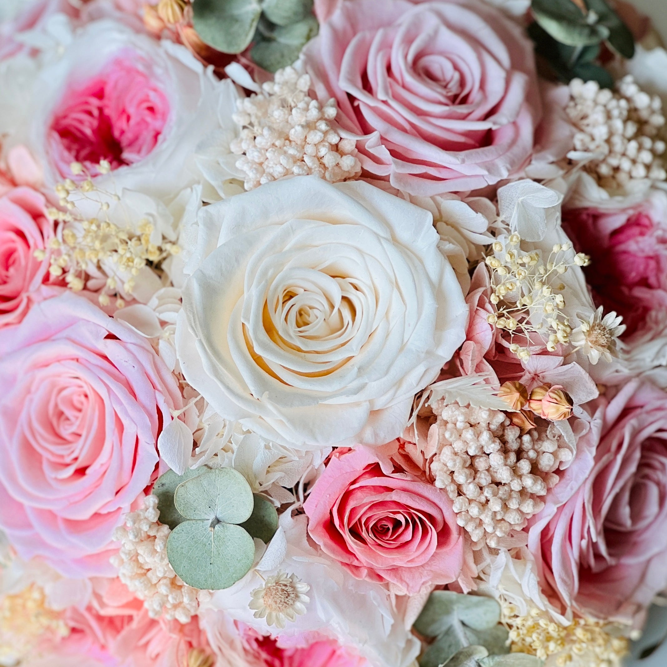 Blushing Beauty Bouquet: Preserved pink and white roses with hydrangeas and baby's breath, accented by soft greenery in an elegant vase. Ideal for gifting.