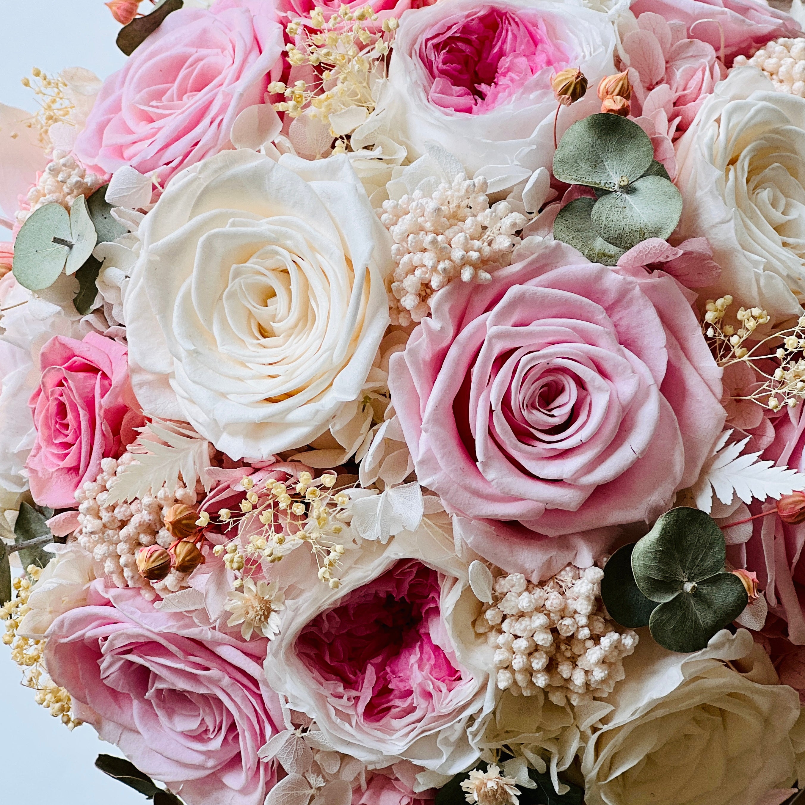 Blushing Beauty Bouquet: Preserved pink and white roses with hydrangeas and baby's breath, accented by soft greenery in an elegant vase. Ideal for gifting.