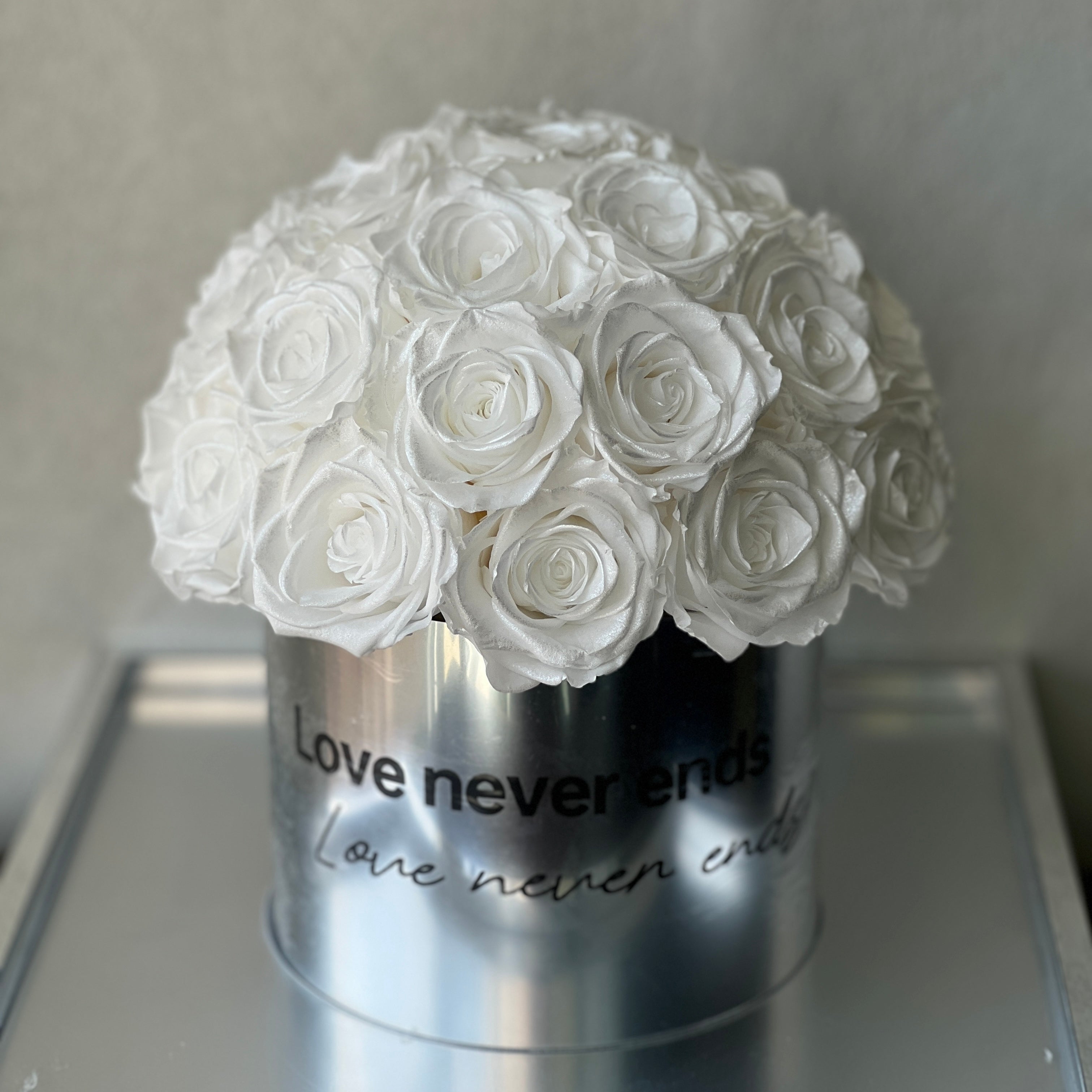 Stunning floral hat box featuring over two dozen preserved white roses, perfect for adding romance to any space. An ideal eternity rose gift for special occasions like Valentine's Day or anniversaries.