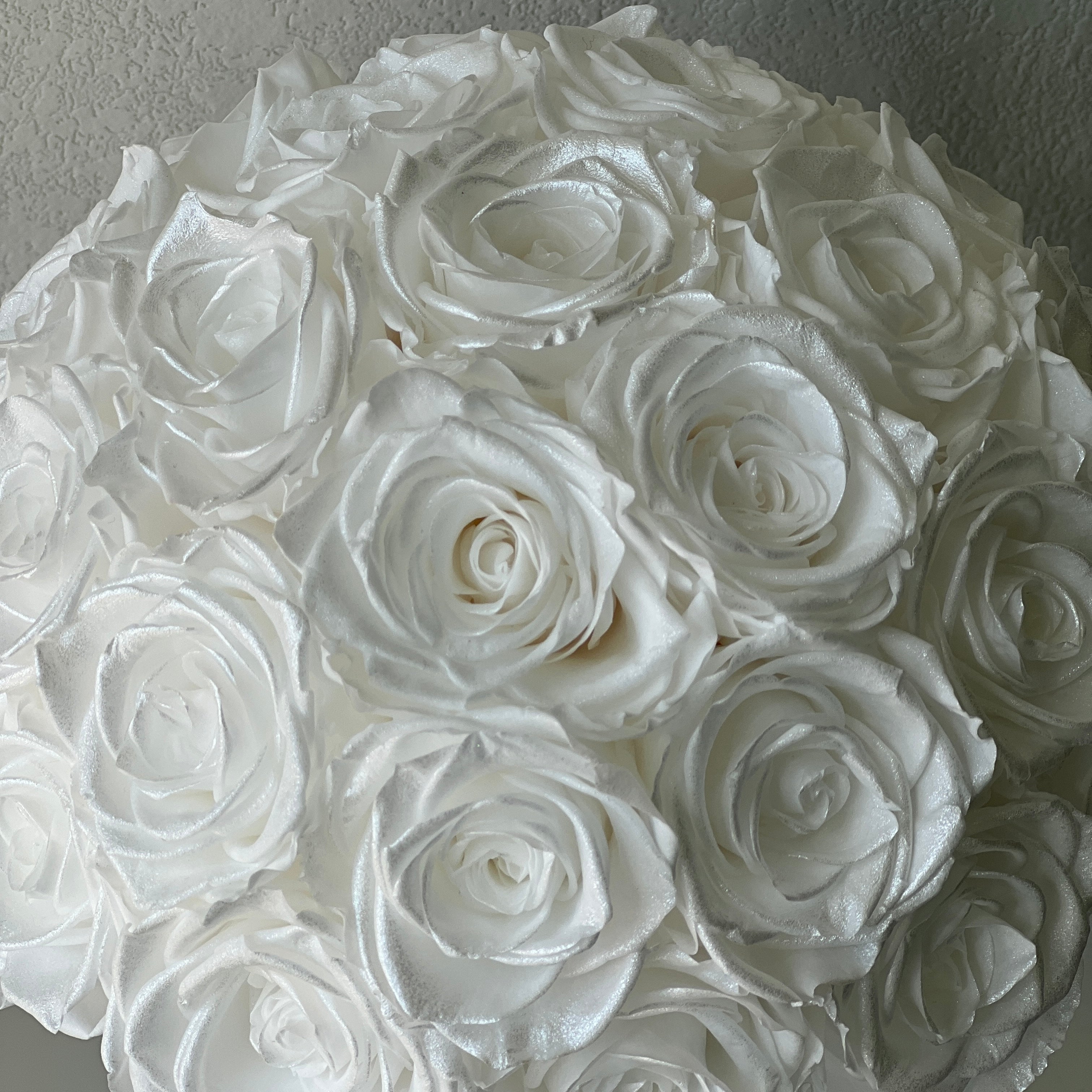 Stunning floral hat box featuring over two dozen preserved white roses, perfect for adding romance to any space. An ideal eternity rose gift for special occasions like Valentine's Day or anniversaries.