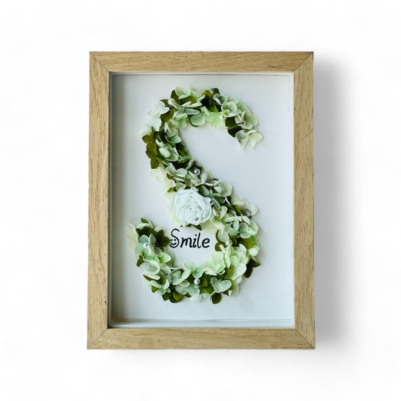 Serene preserved floral letter art featuring a white rose with soft green hydrangeas and pearl accents, framed in natural wood—a perfect calming gift.