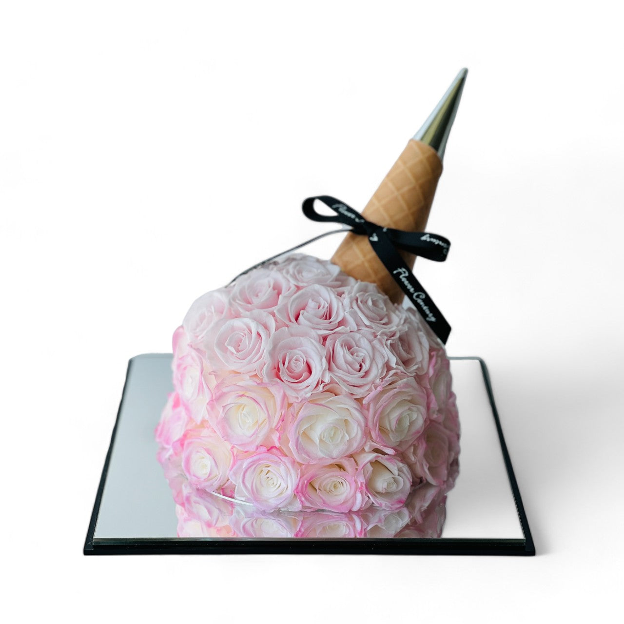 Whimsical Bouquet Cone featuring soft pink preserved roses in an ice cream cone-inspired wrap with a metallic tip. A playful and elegant eternity rose gift perfect for special occasions.