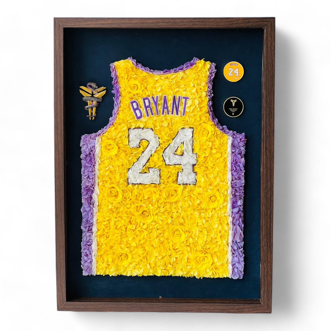 Preserved floral tribute to Kobe Bryant's iconic number 24 jersey, featuring roses and hydrangeas in yellow and purple, framed in dark wood. A perfect piece for collectors and enthusiasts.