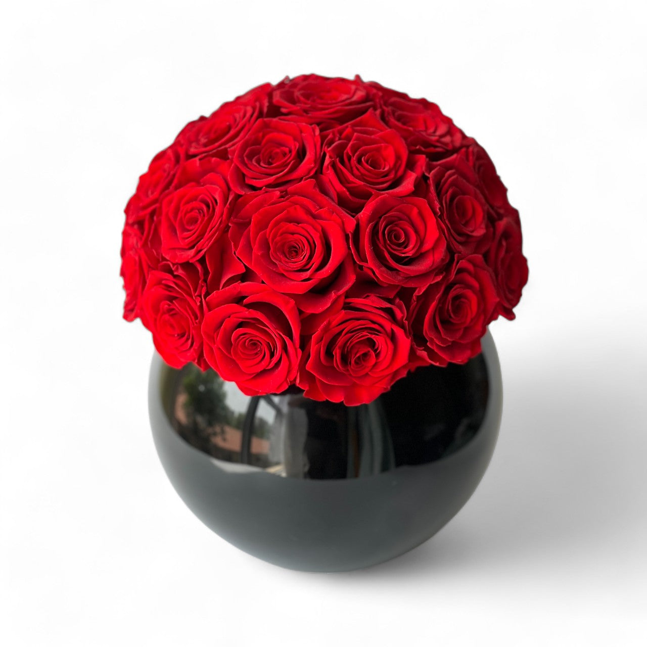 A sphere of preserved red roses in a glossy black vase, perfect for adding sophistication to any space. Maintenance-free and ideal for gifting.