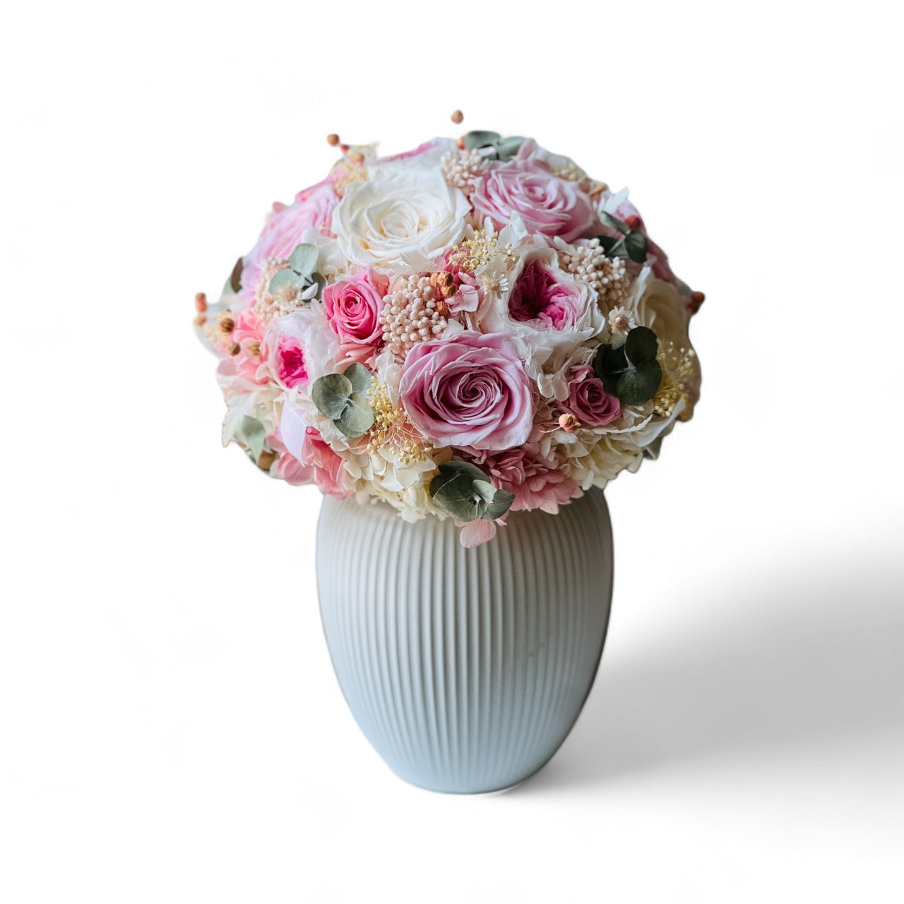 Blushing Beauty Bouquet: Preserved pink and white roses with hydrangeas and baby's breath, accented by soft greenery in an elegant vase. Ideal for gifting.