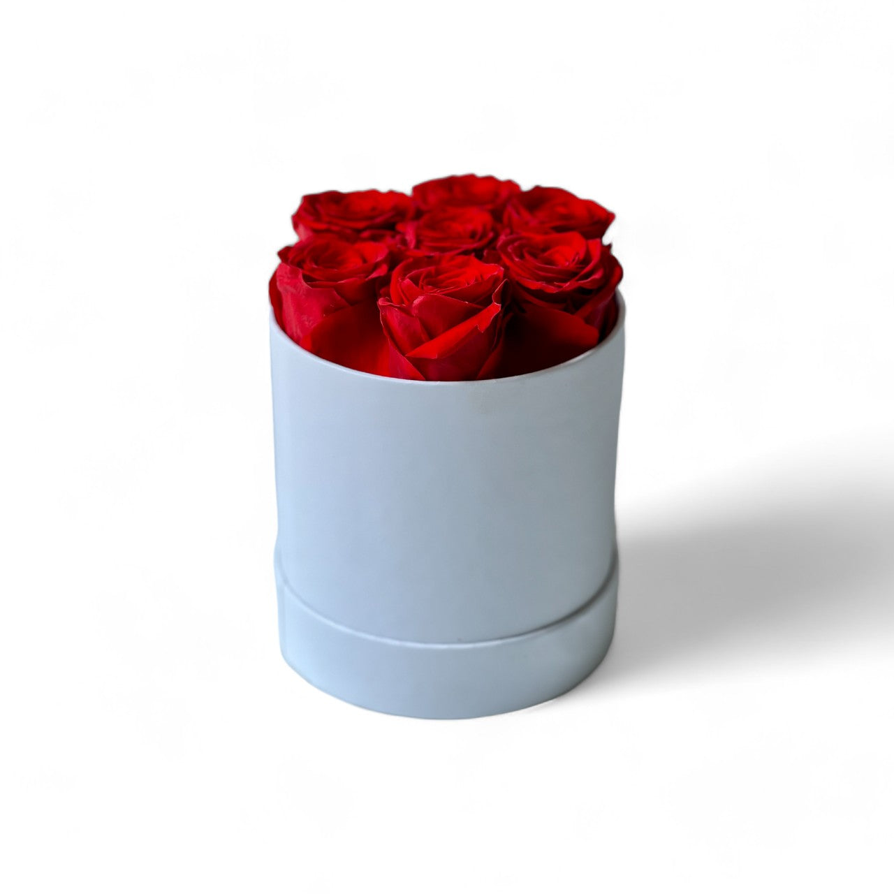 The Scarlet Elegance preserved flower arrangement features a stunning collection of deep red roses, carefully encased in a sleek white box. A perfect eternity rose gift exuding romance and sophistication, ideal for any special occasion.