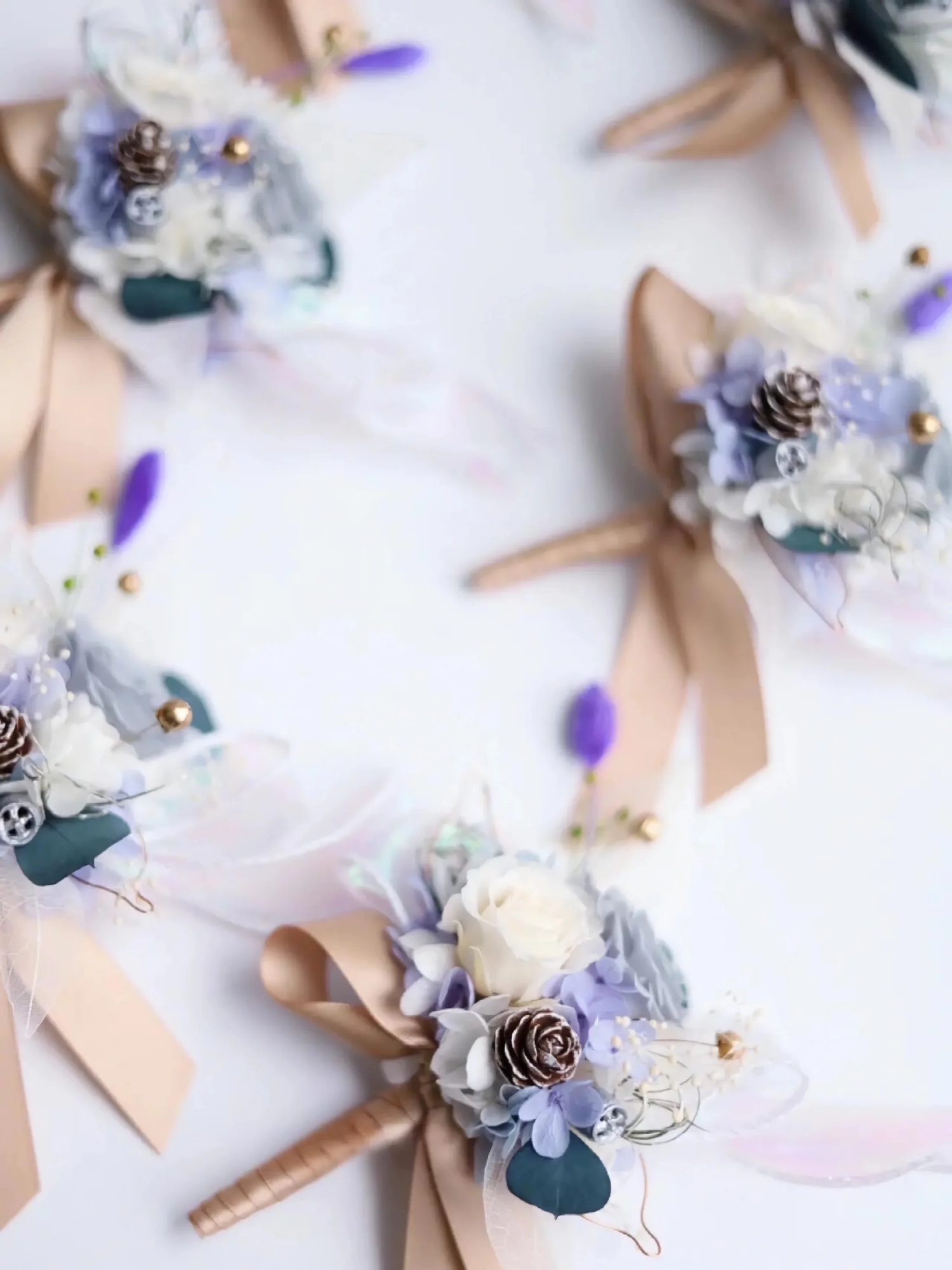 Elegant boutonnieres featuring wedding flowers in dusty blue hues, accented with French lavender and ranunculus flowers. Perfect for adding a sophisticated touch to any boutineer arrangement.