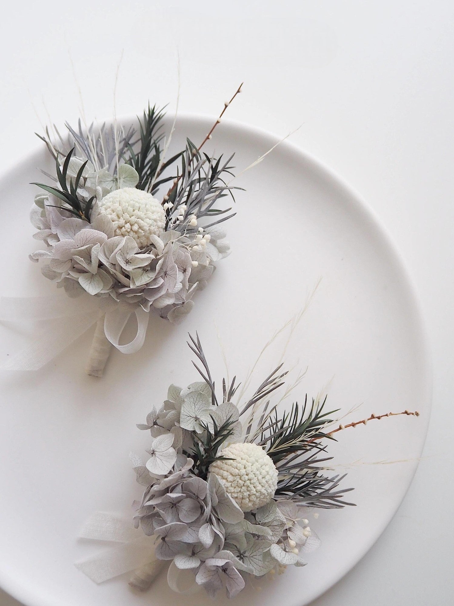 Ivory and gray hydrangea boutonniere with textured ivory ball accent.
