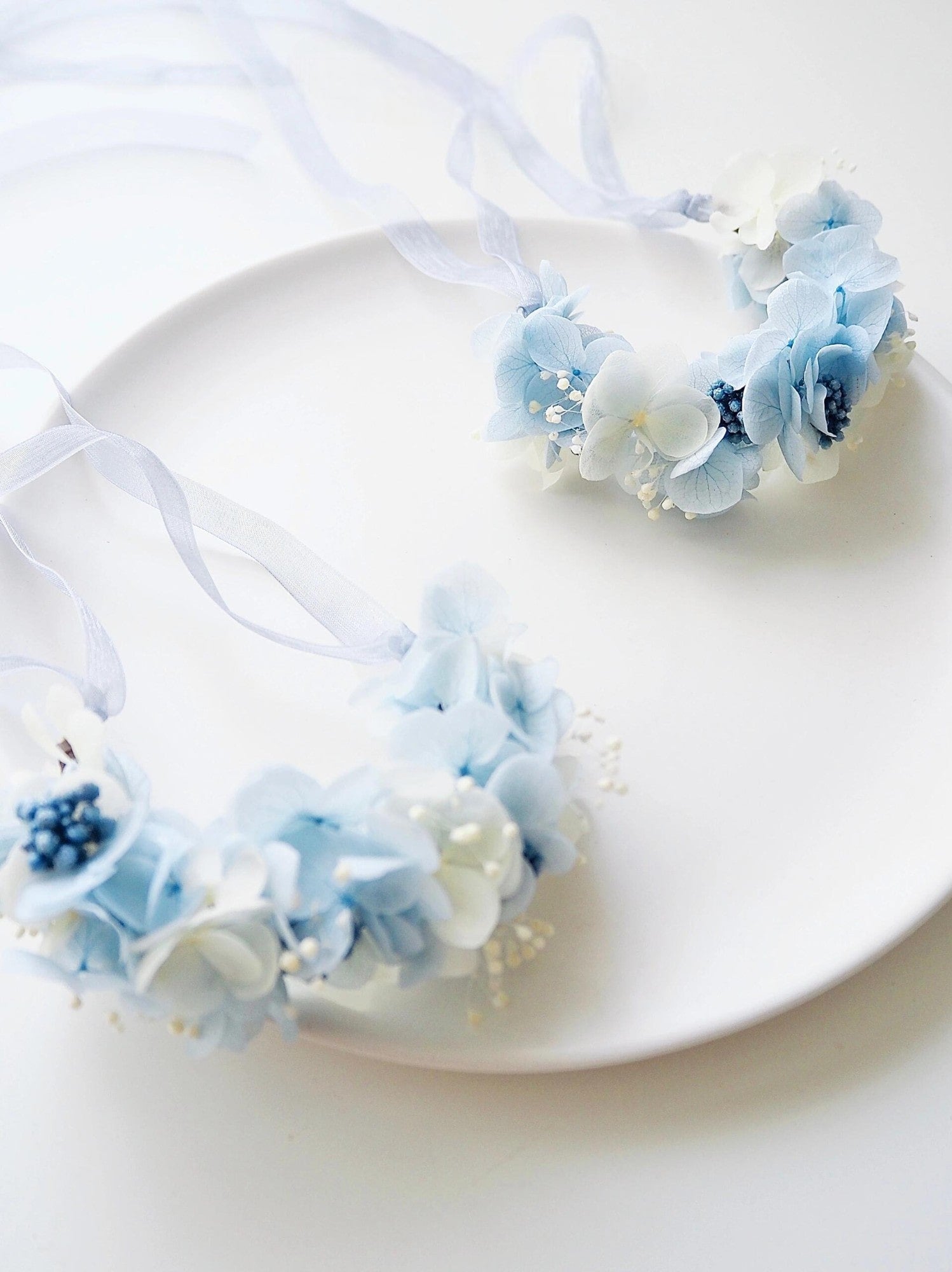 Wedding corsages featuring blue hydrangea flowers and baby’s breath.
