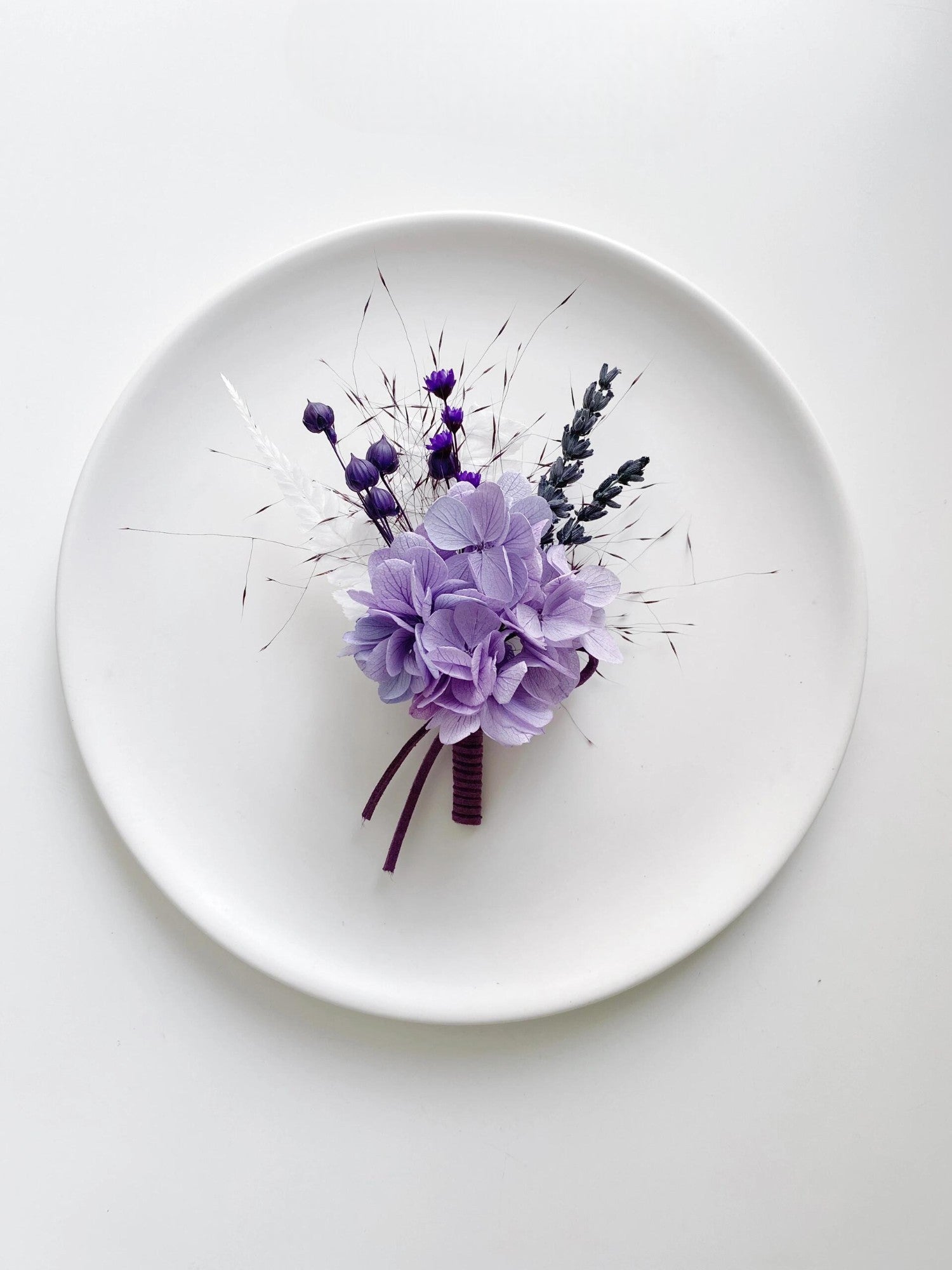 Elegant wedding boutonniere featuring lavender and purple flowers.
