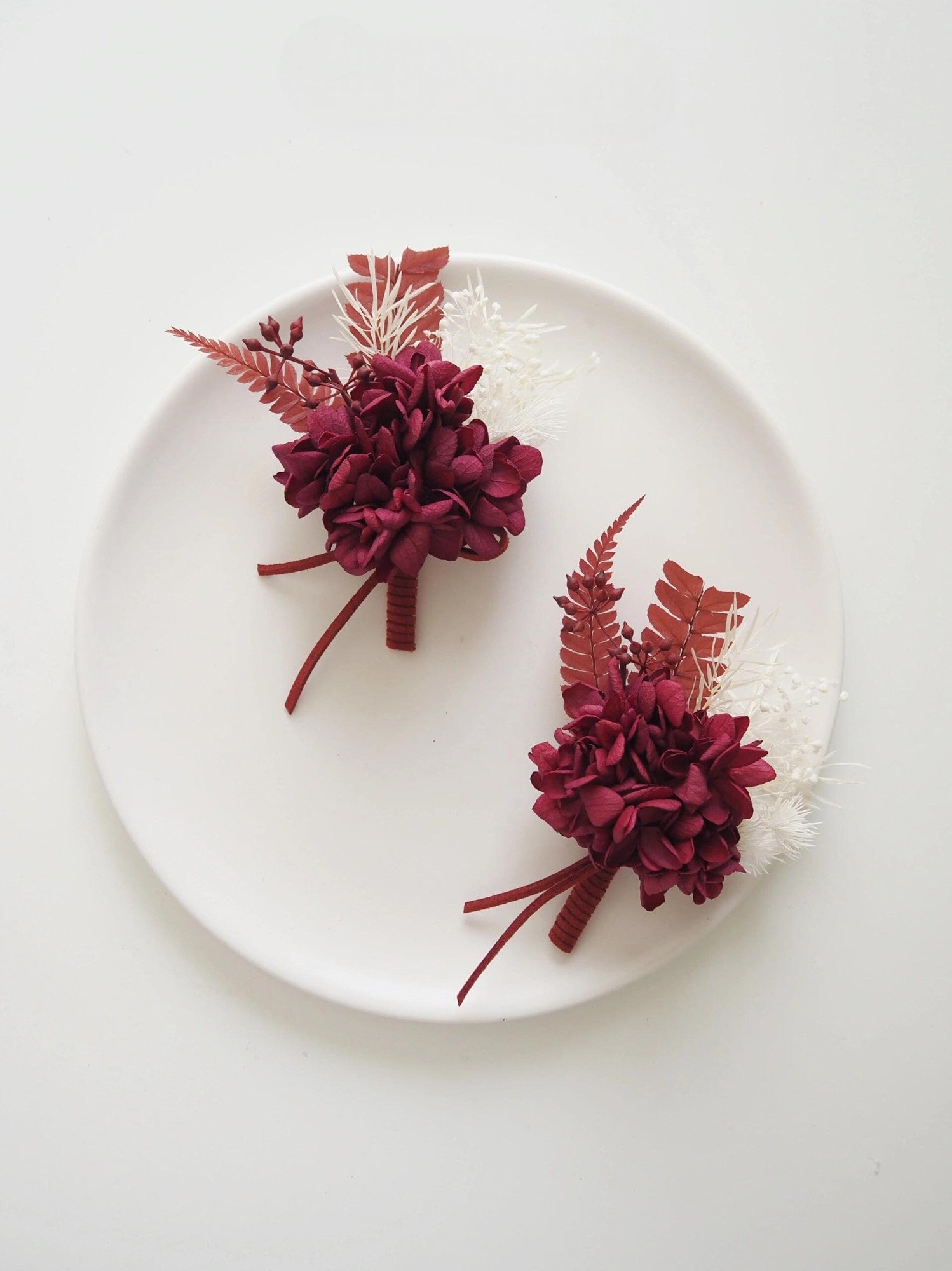 Burgundy hydrangea and rust fern preserved flower boutonniere for weddings
