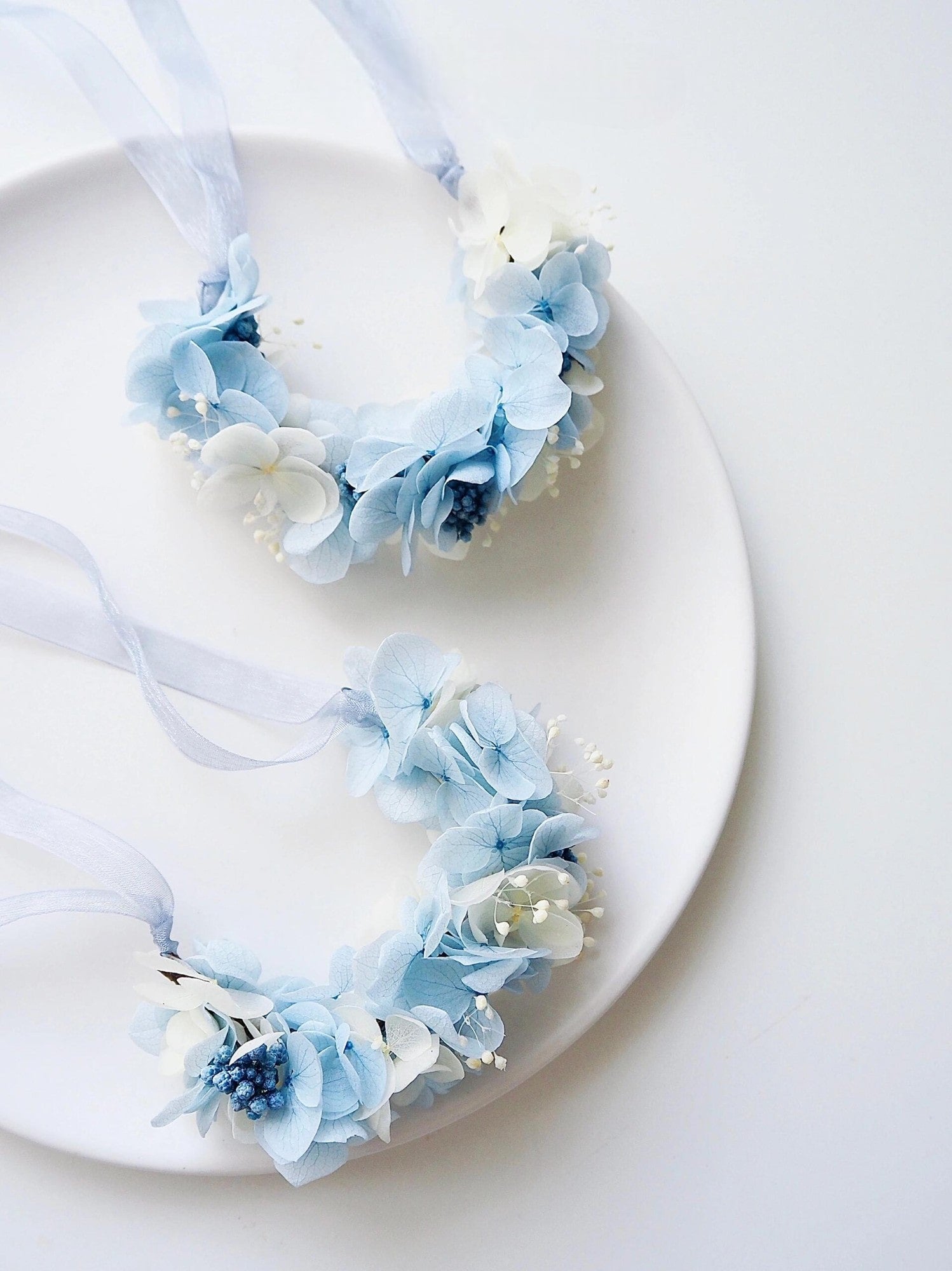 Pair of blue hydrangea and baby's breath corsages with delicate ribbon.
