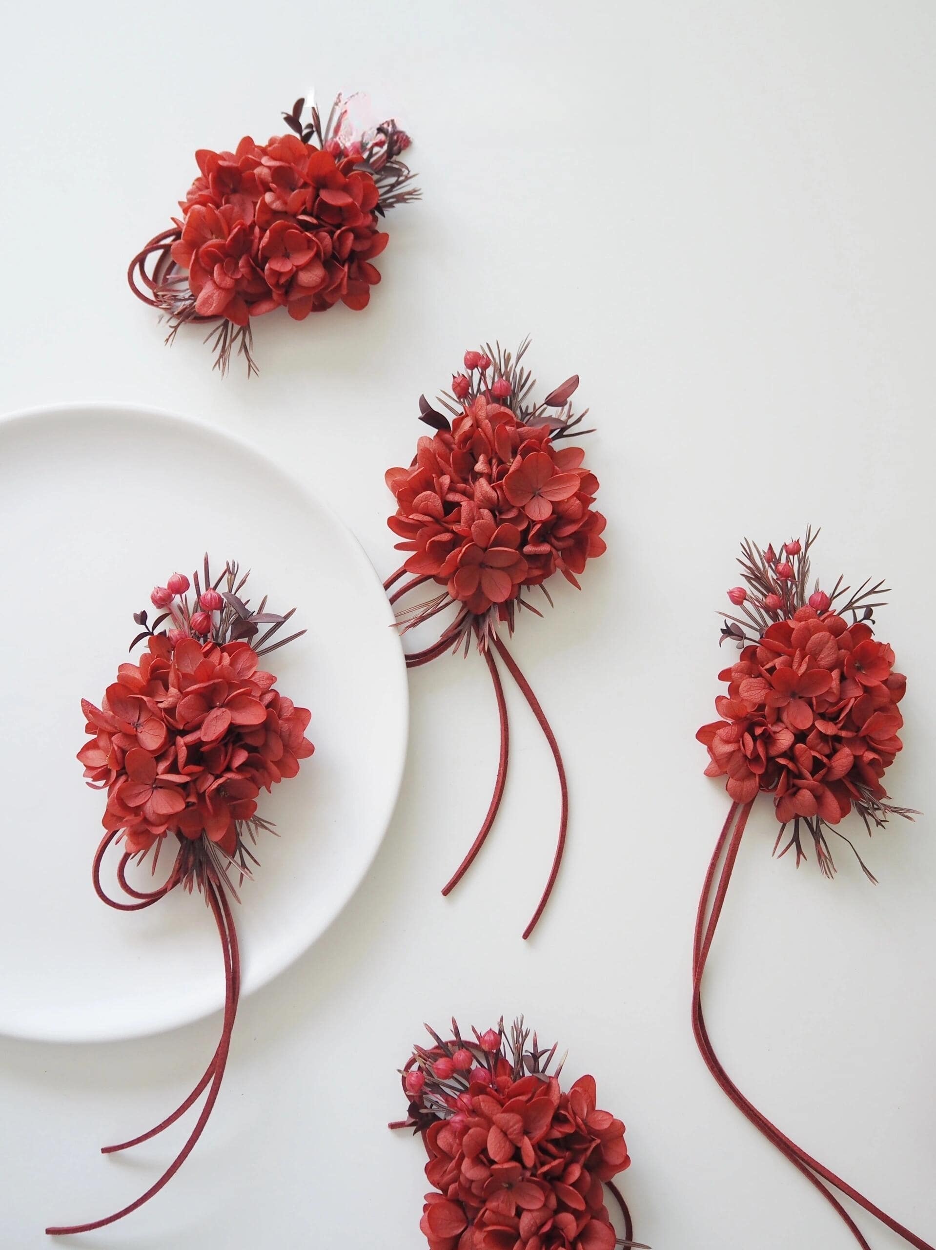 Preserved flower corsage featuring red hydrangeas and matching ribbon
