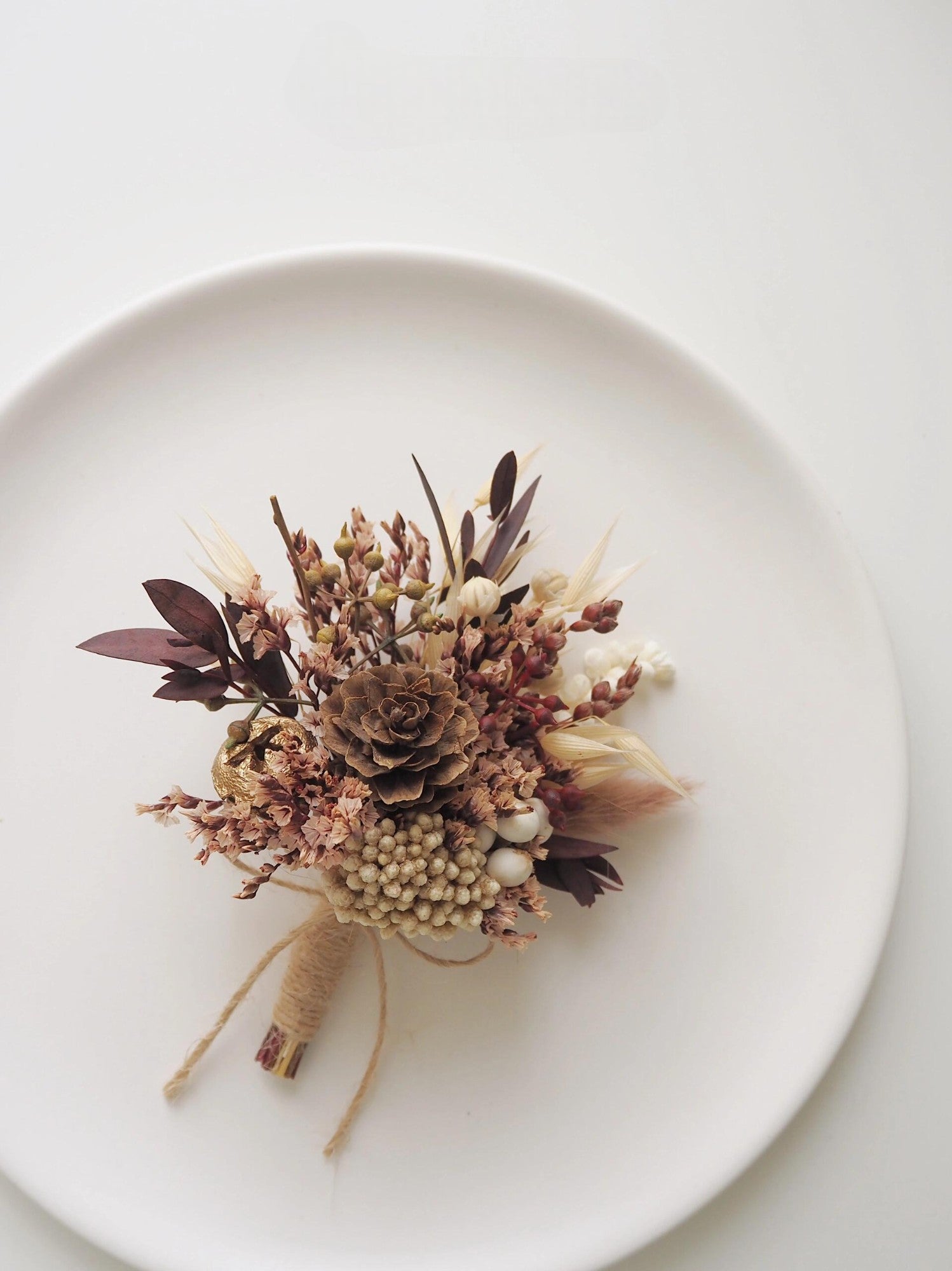 Woodland-inspired boutonniere with berries and dried accents
