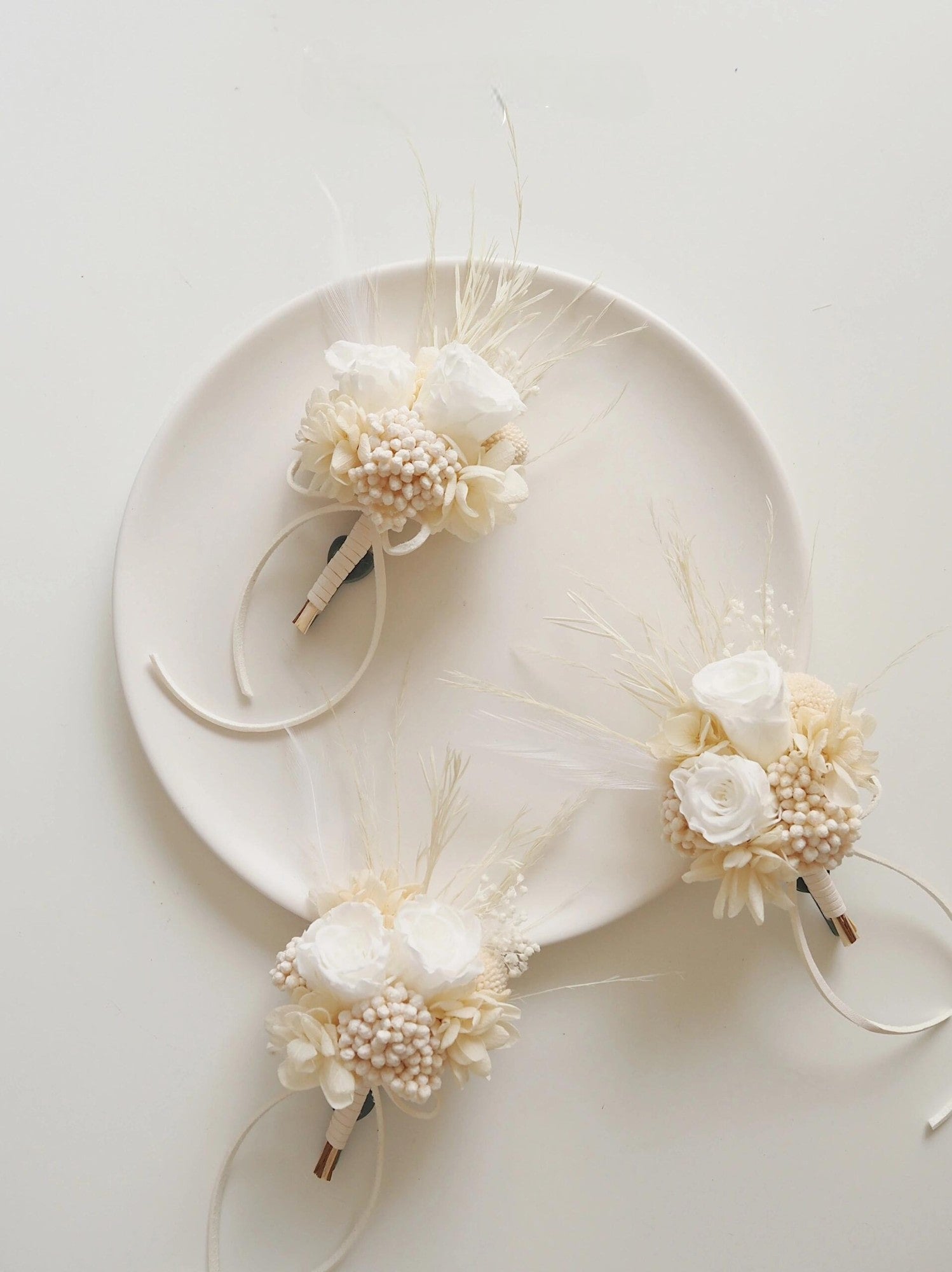 Ivory rose and pearl accented preserved flower boutonniere for weddings
