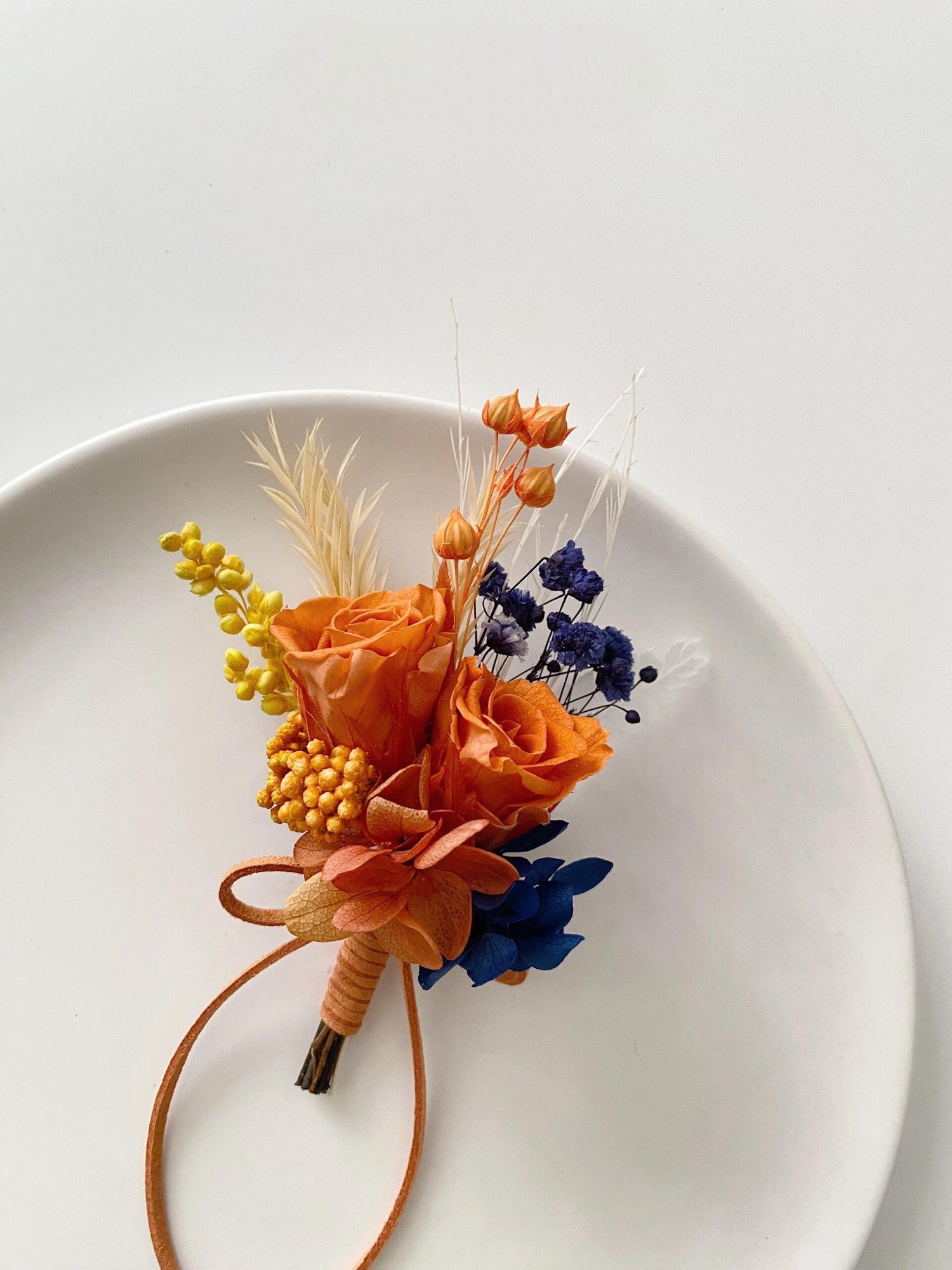 Terracotta and navy blue preserved flower boutonniere for weddings
