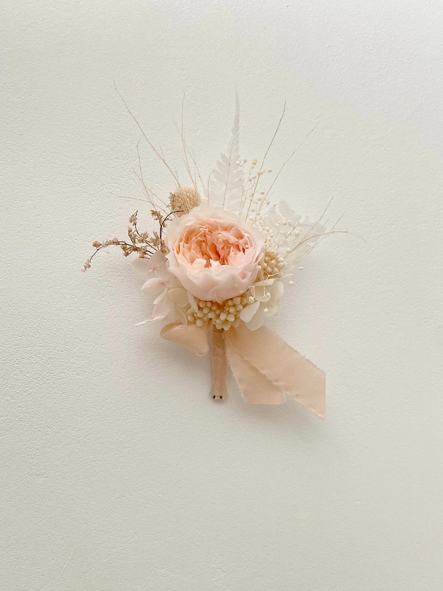 Blush peony and preserved flower boutonniere for elegant weddings
