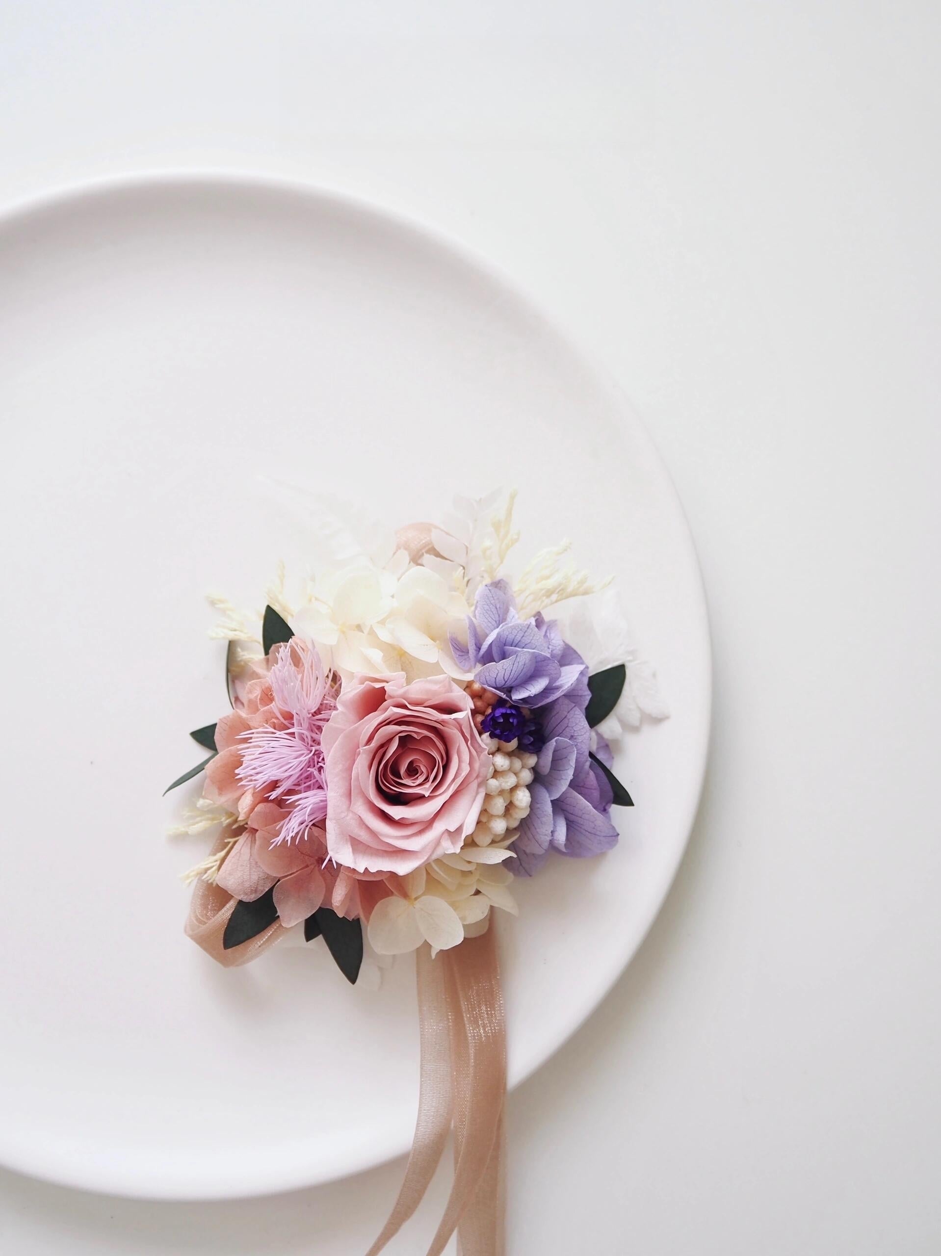 Elegant boutonniere and corsage set with blush roses and purple accents
