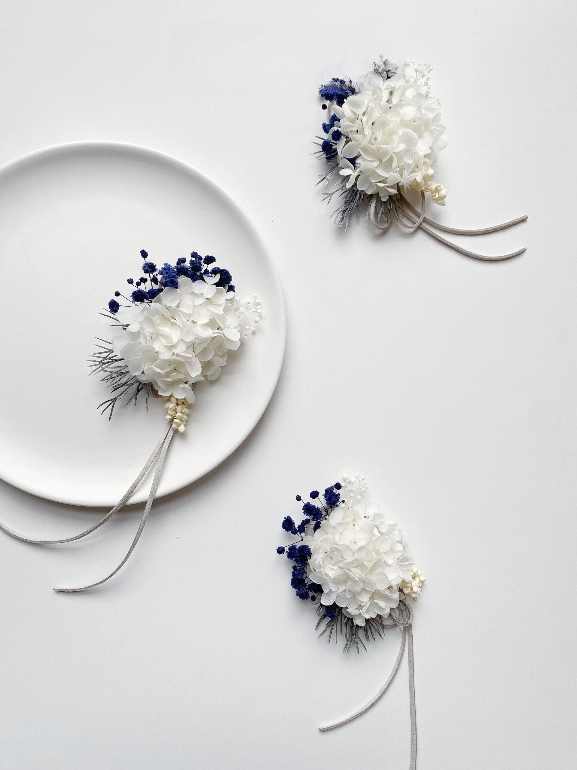 Elegant wedding corsage featuring white hydrangeas and blue statice
