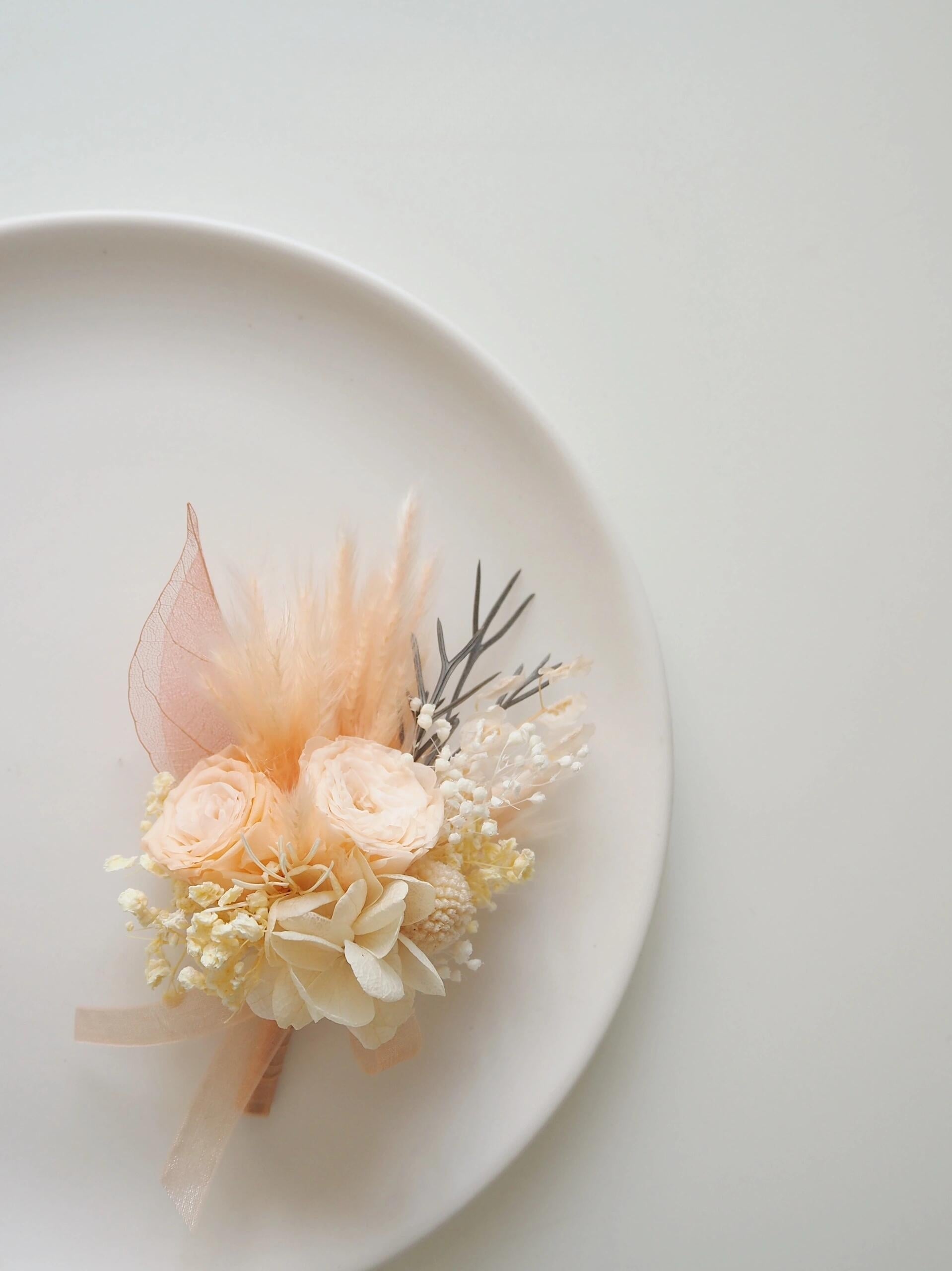 Soft peach and ivory preserved flower boutonniere for groomsmen
