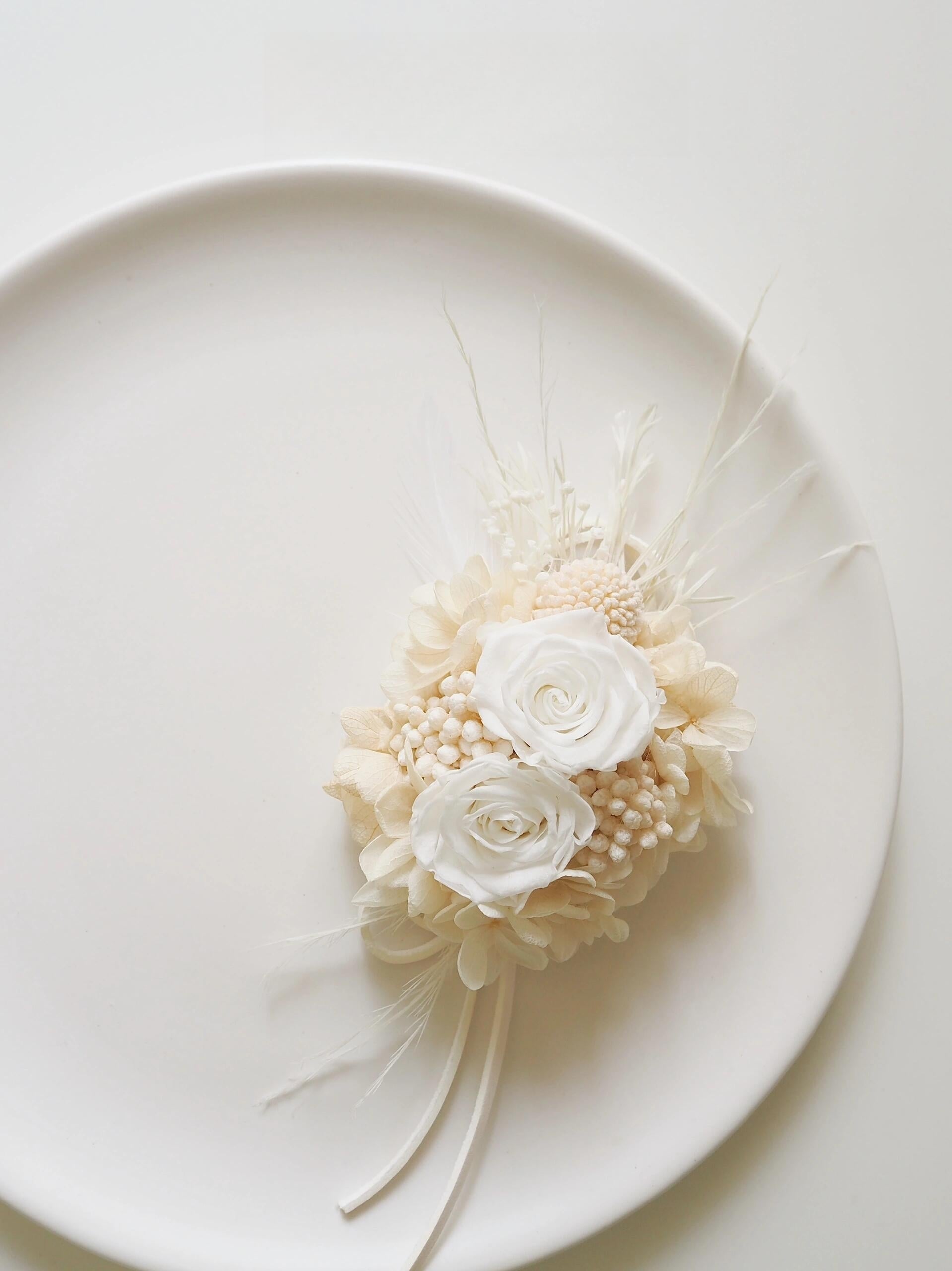 Wedding corsage with preserved ivory roses and delicate white flowers
