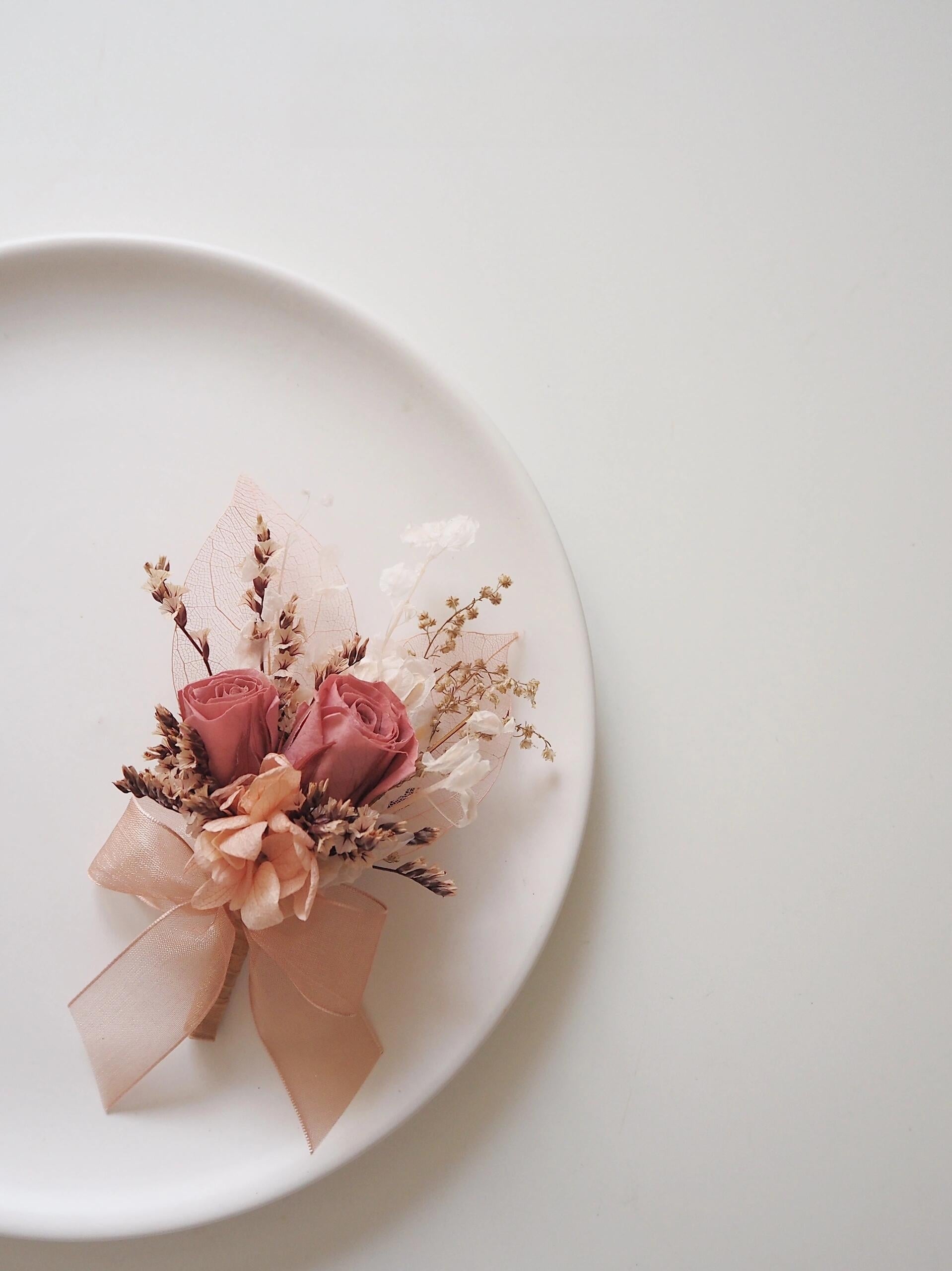 Elegant dusty rose boutonniere with preserved flowers and peach accents
