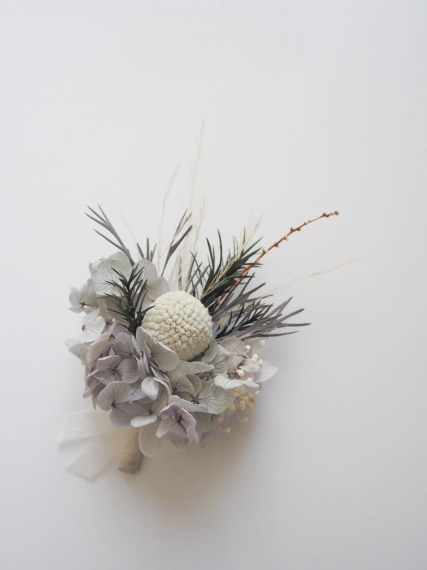 Classic boutonniere with ivory textured centerpiece and gray hydrangeas.
