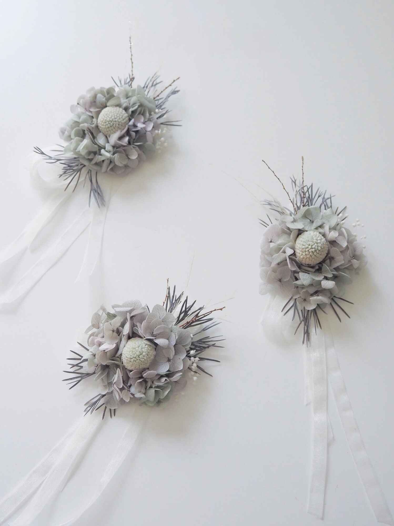 Sophisticated gray floral corsage with delicate ribbons.
