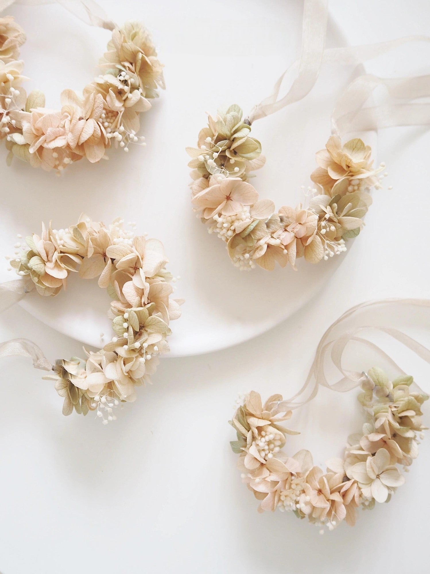 Close-up of delicate beige hydrangea and baby's breath wrist corsage.
