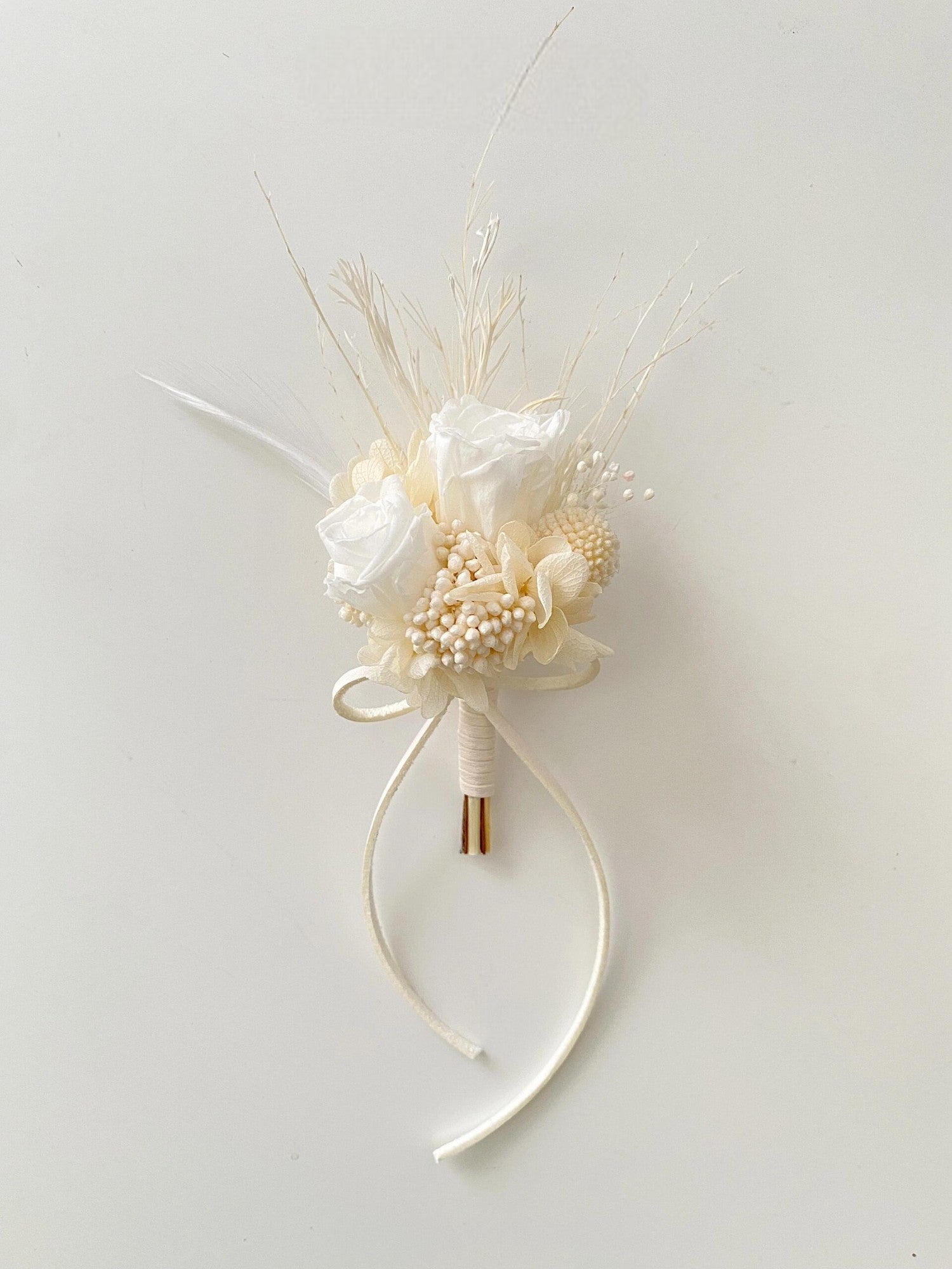 Elegant white rose boutonniere with dried floral accents
