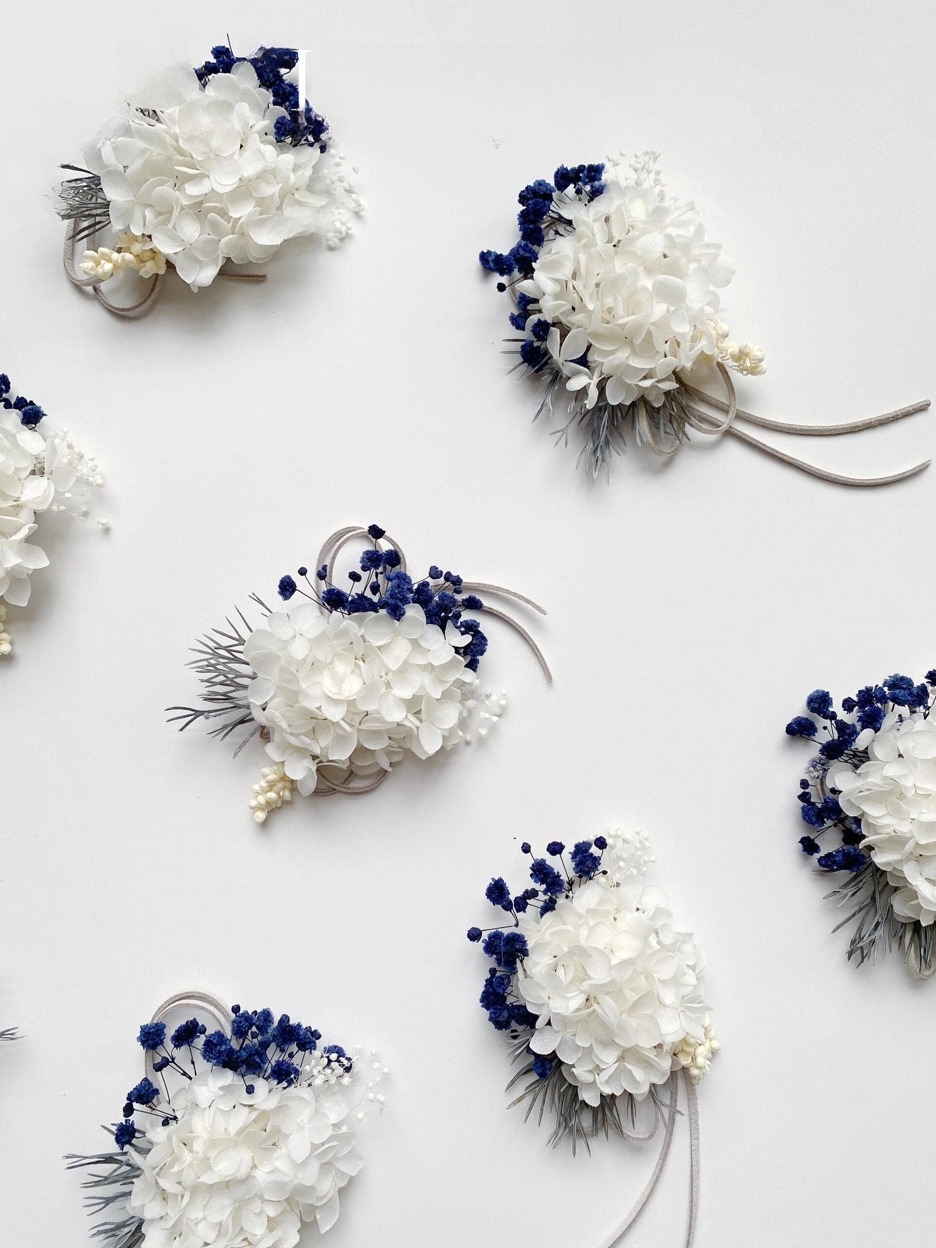 Preserved white hydrangea corsage with blue statice flowers
