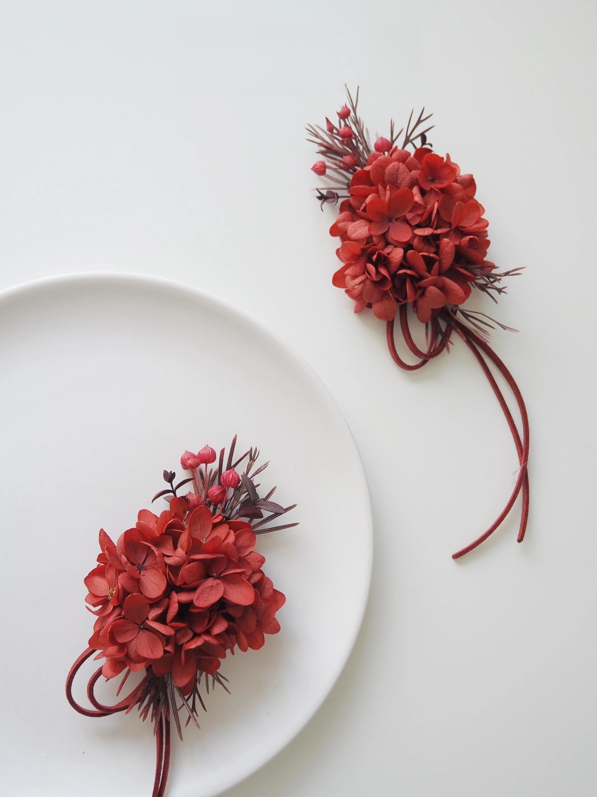 Vibrant red wedding corsage with preserved hydrangeas and berries
