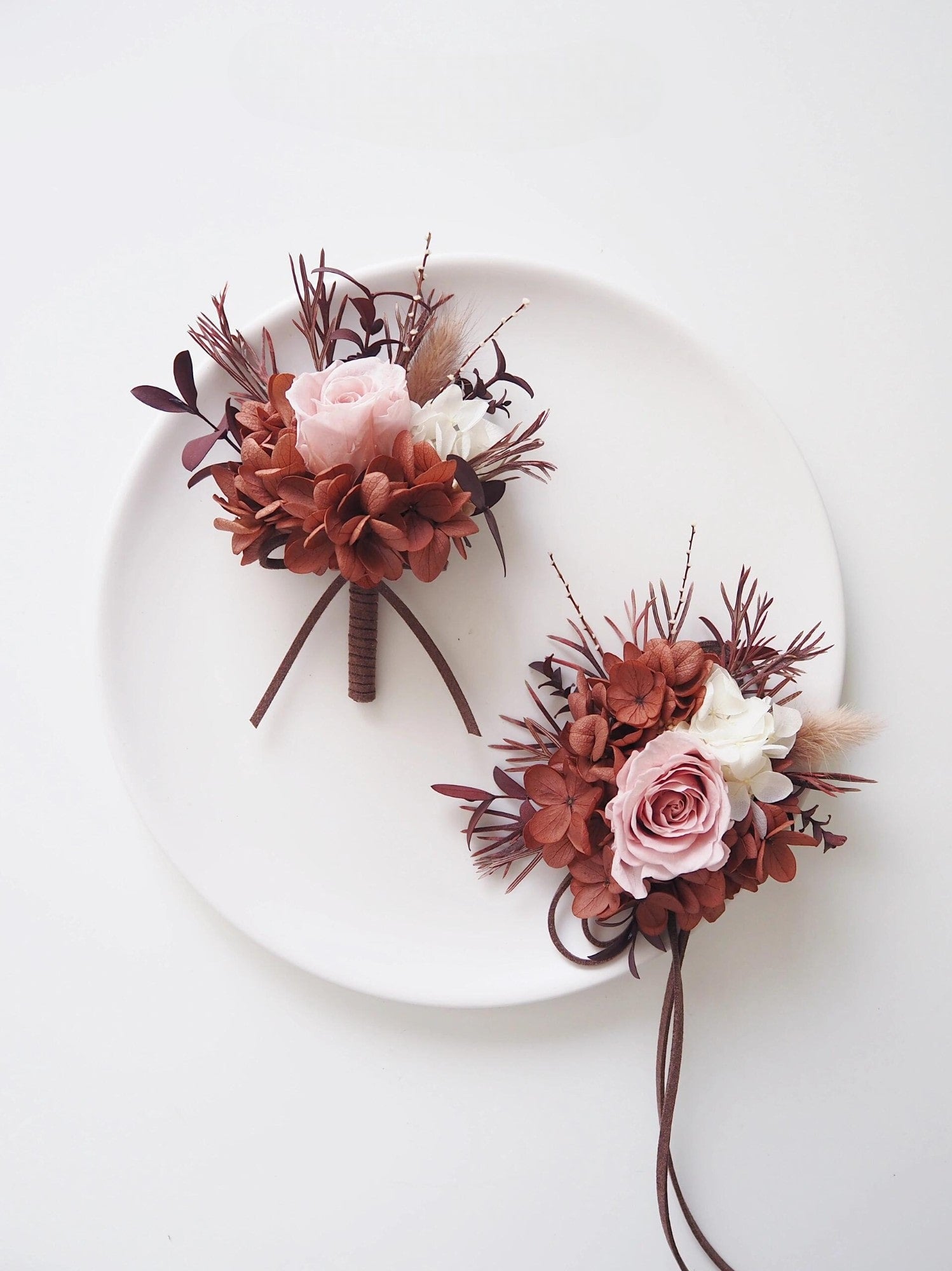 Wedding boutonniere and corsage set with preserved blush roses and rust tones
