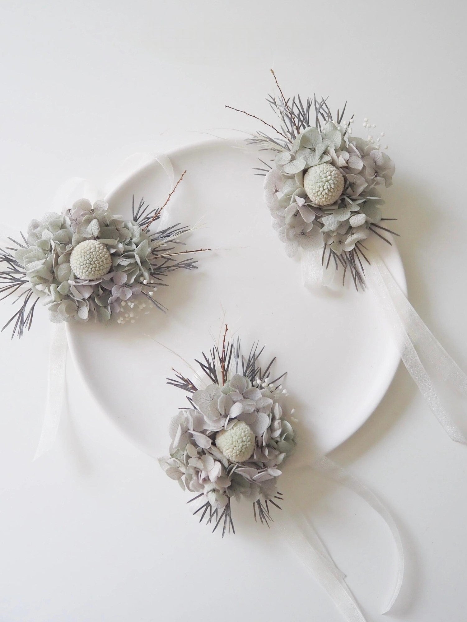 Elegant wedding corsage with preserved sage hydrangeas and greenery
