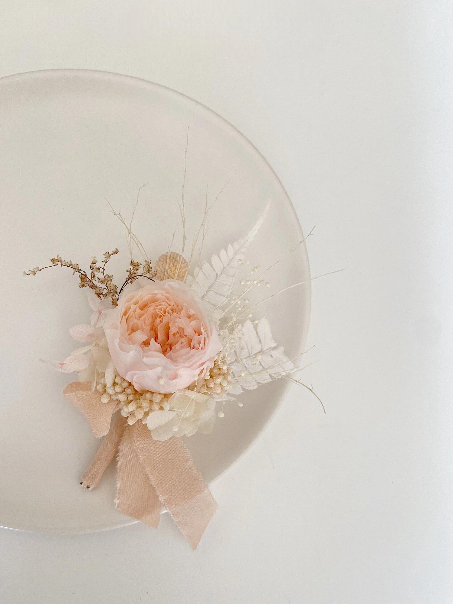 Blush peony boutonniere with baby's breath and preserved accents
