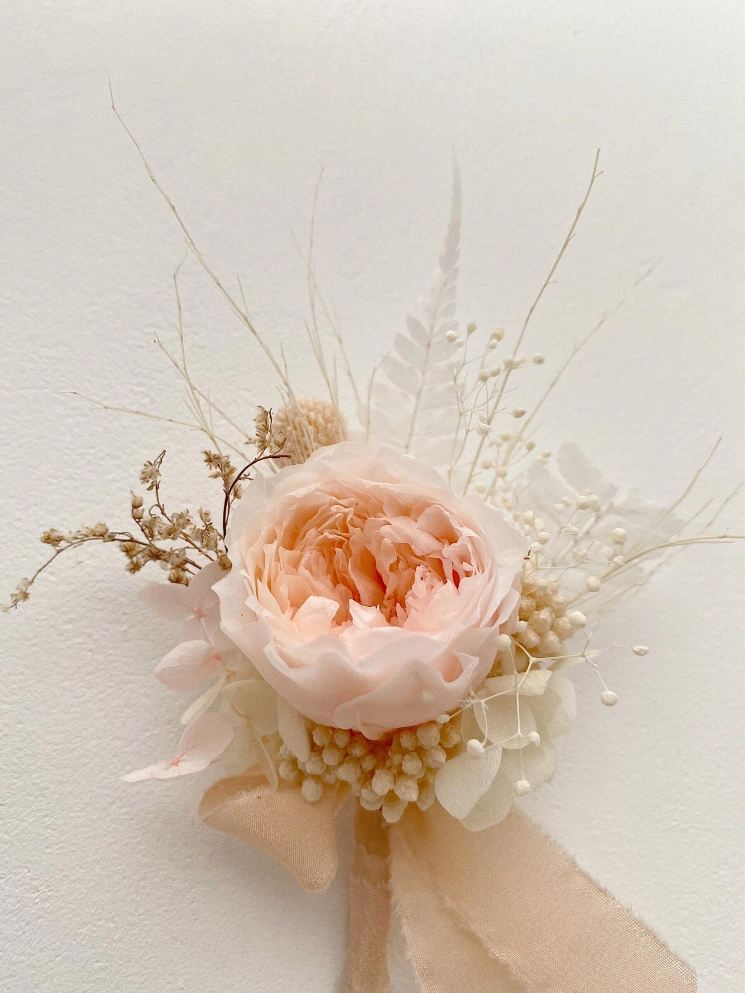 Soft blush peony boutonniere with delicate dried flowers for weddings
