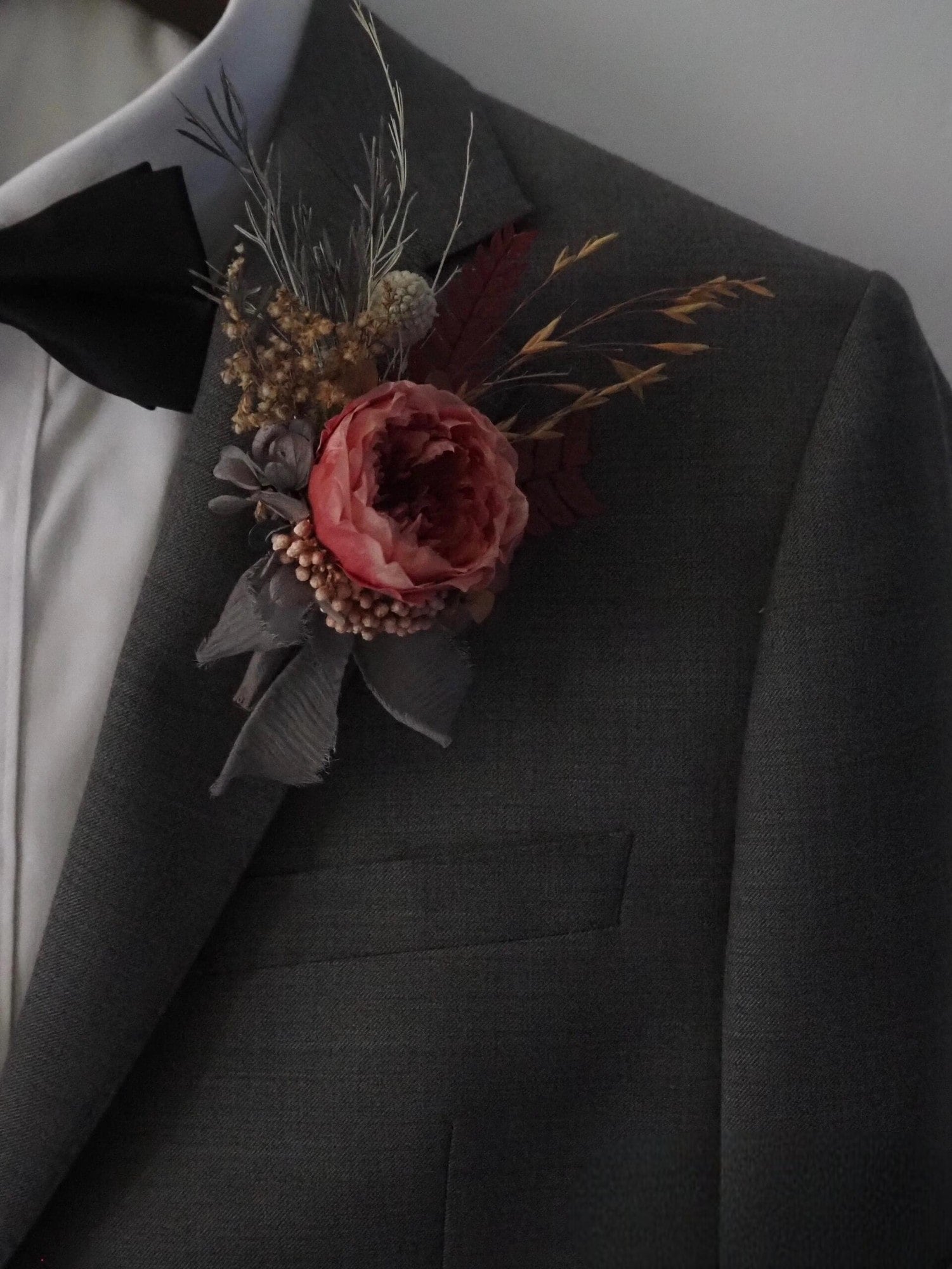 Elegant wedding boutonniere with dusty rose peony and dried accents
